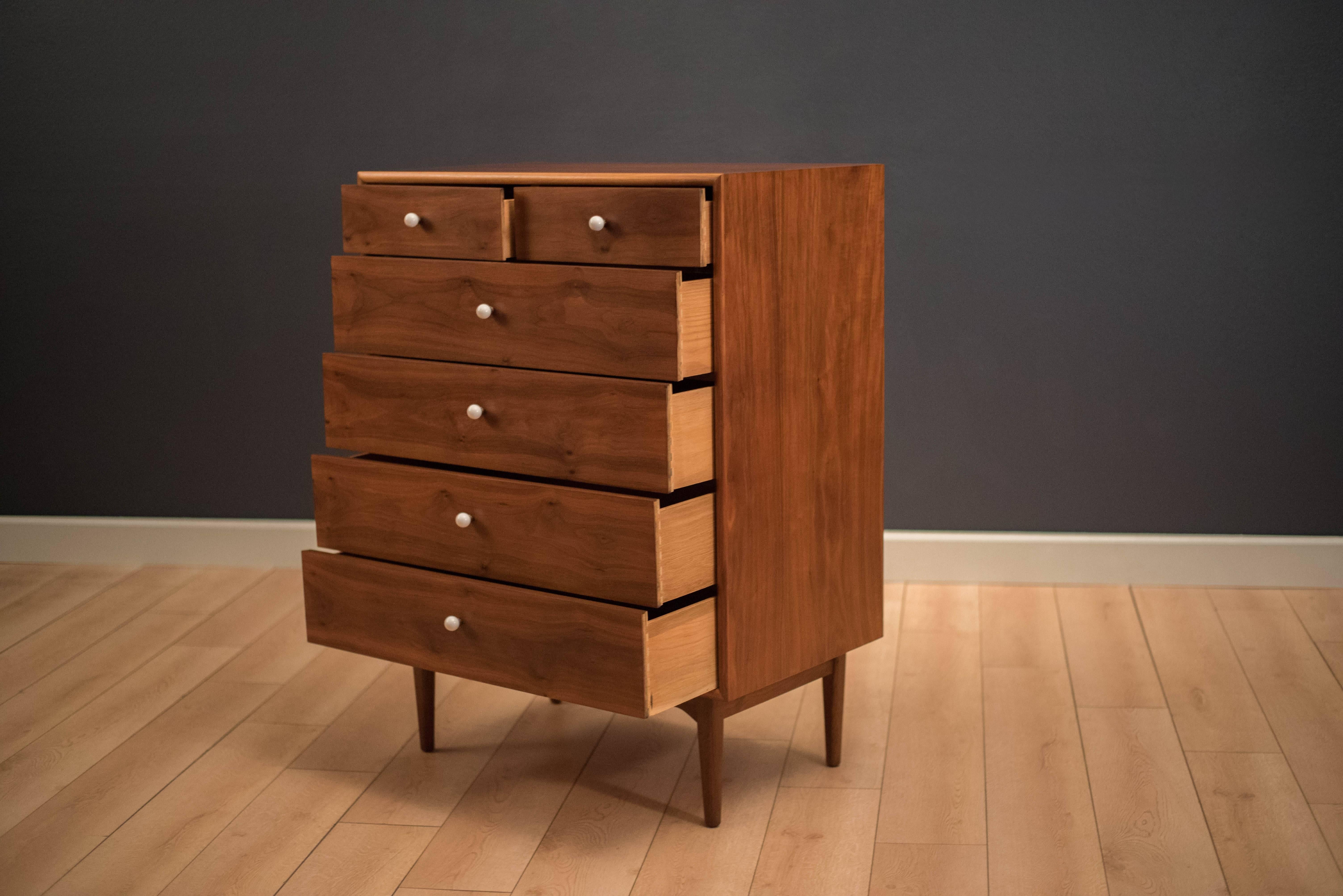 Mid Century Drexel declaration highboy dresser by Kipp Stewart & Stewart McDougall. This piece displays continuous black walnut grains and includes six dovetailed drawers with the original porcelain white knobs.