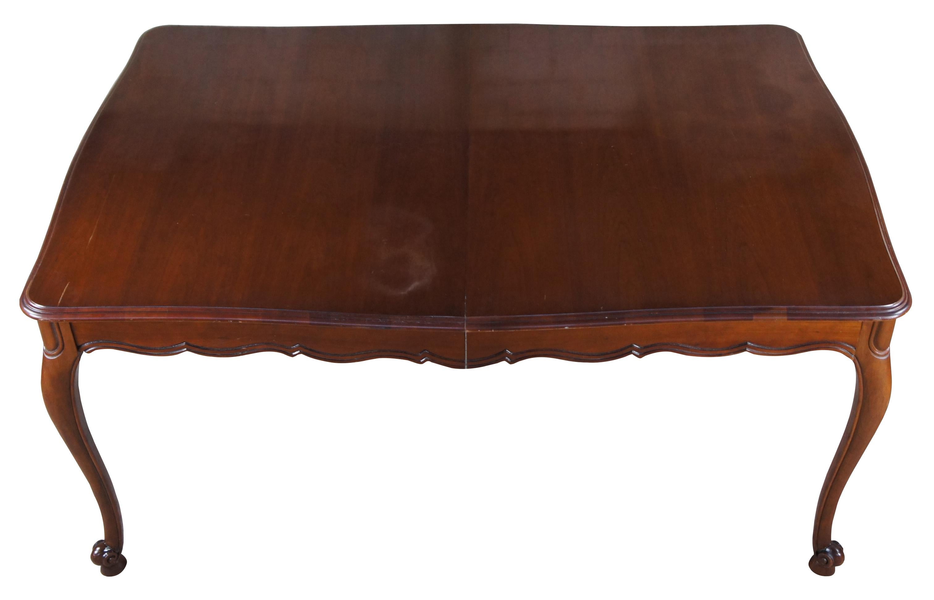Vintage Drexel Heritage French Provincial dining table. Made of cherry featuring scalloped rectangular form with fluted accents, cabriole legs and three extending leaves (12