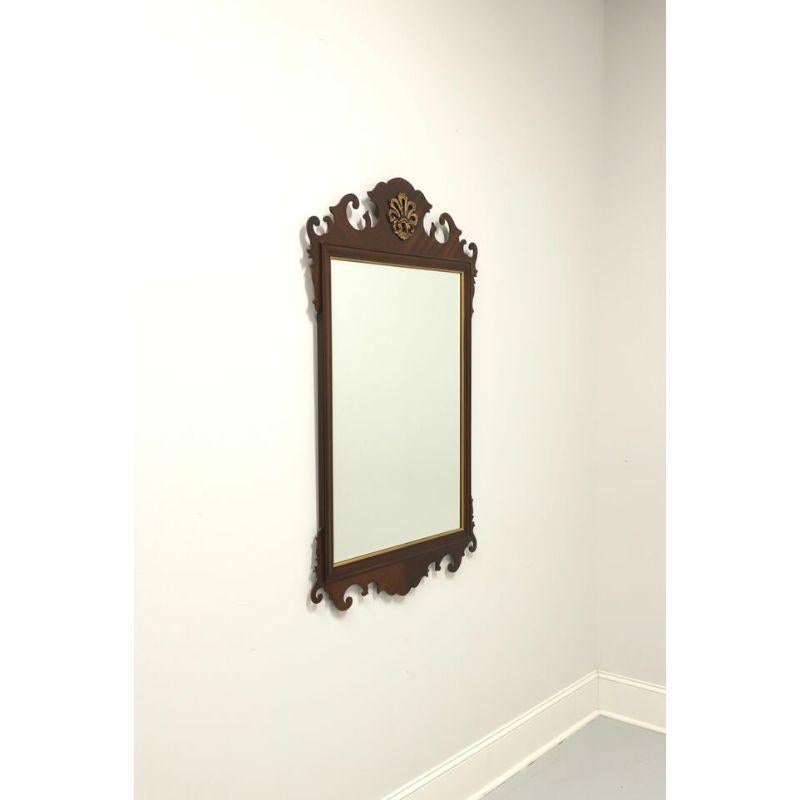 A large Chippendale style wall mirror by Drexel Heritage, from their 18th Century Classics Collection. Bevel edge mirrored glass, mahogany frame with gold trim and top center fleur-de-lis. Made in Drexel, North Carolina, USA, circa 1987 

Style #: