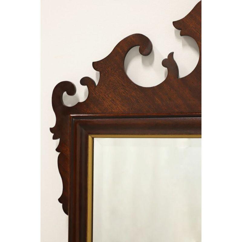 A large Chippendale style wall mirror by Drexel Heritage, from their 18th Century Classics Collection. Bevel edge mirrored glass, mahogany frame with gold trim and top center fleur-de-lis. Made in Drexel, North Carolina, USA, circa 1987. 

Style #: