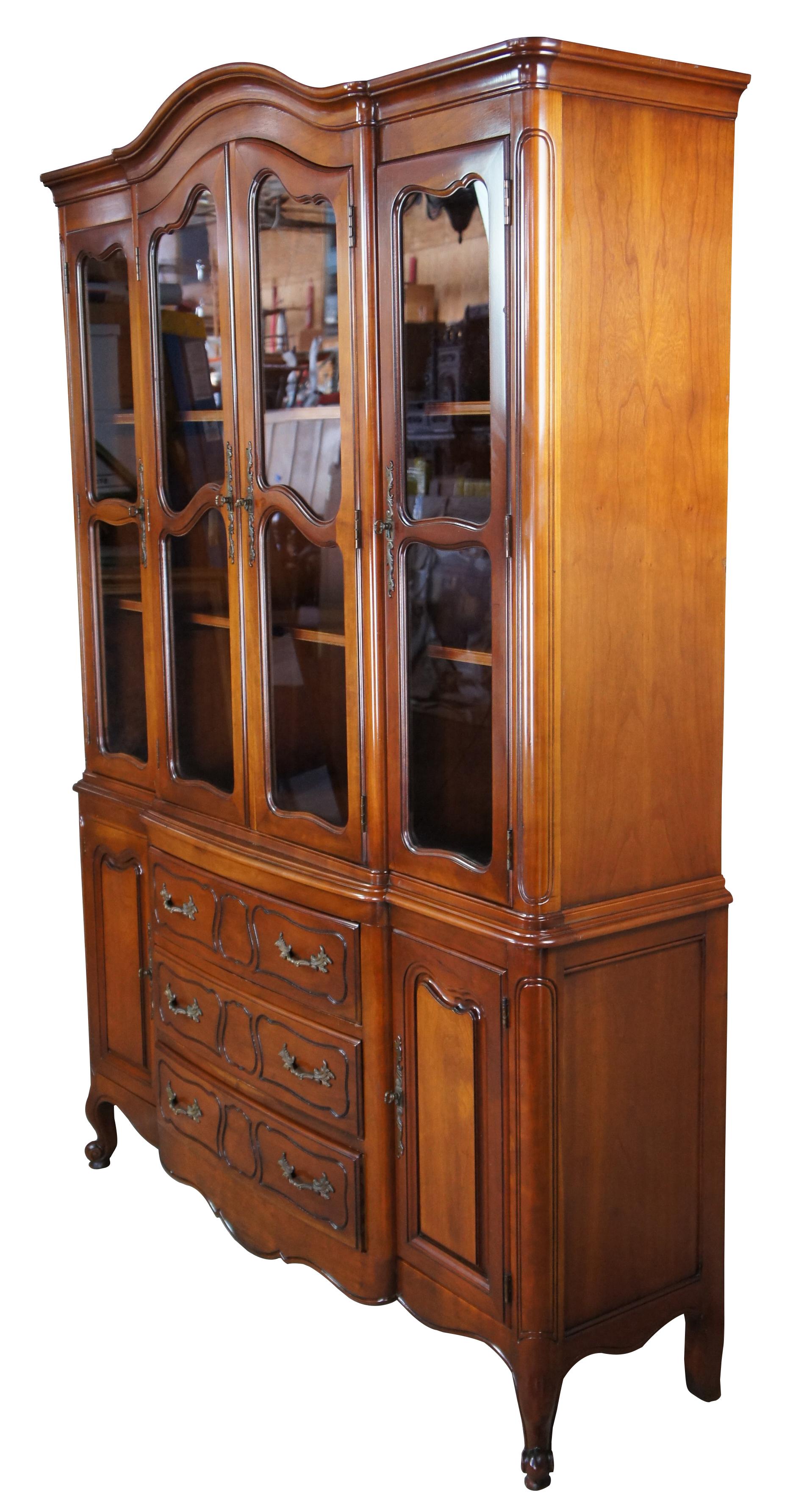Vintage 1985 Drexel Heritage French Provincial china cabinet. Made of cherry featuring rectangular serpentine form with a breakfront, domed top, and cabriole legs. 3087, 1151. Size: 72