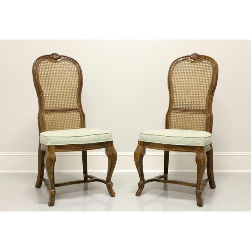 A pair of French Provincial style dining side chairs by Drexel Heritage. Solid oak with shell carved tops, cane seat backs, mint green fabric upholstered seats, curved legs and stretcher base. Made in North Carolina, USA, in the late 20th