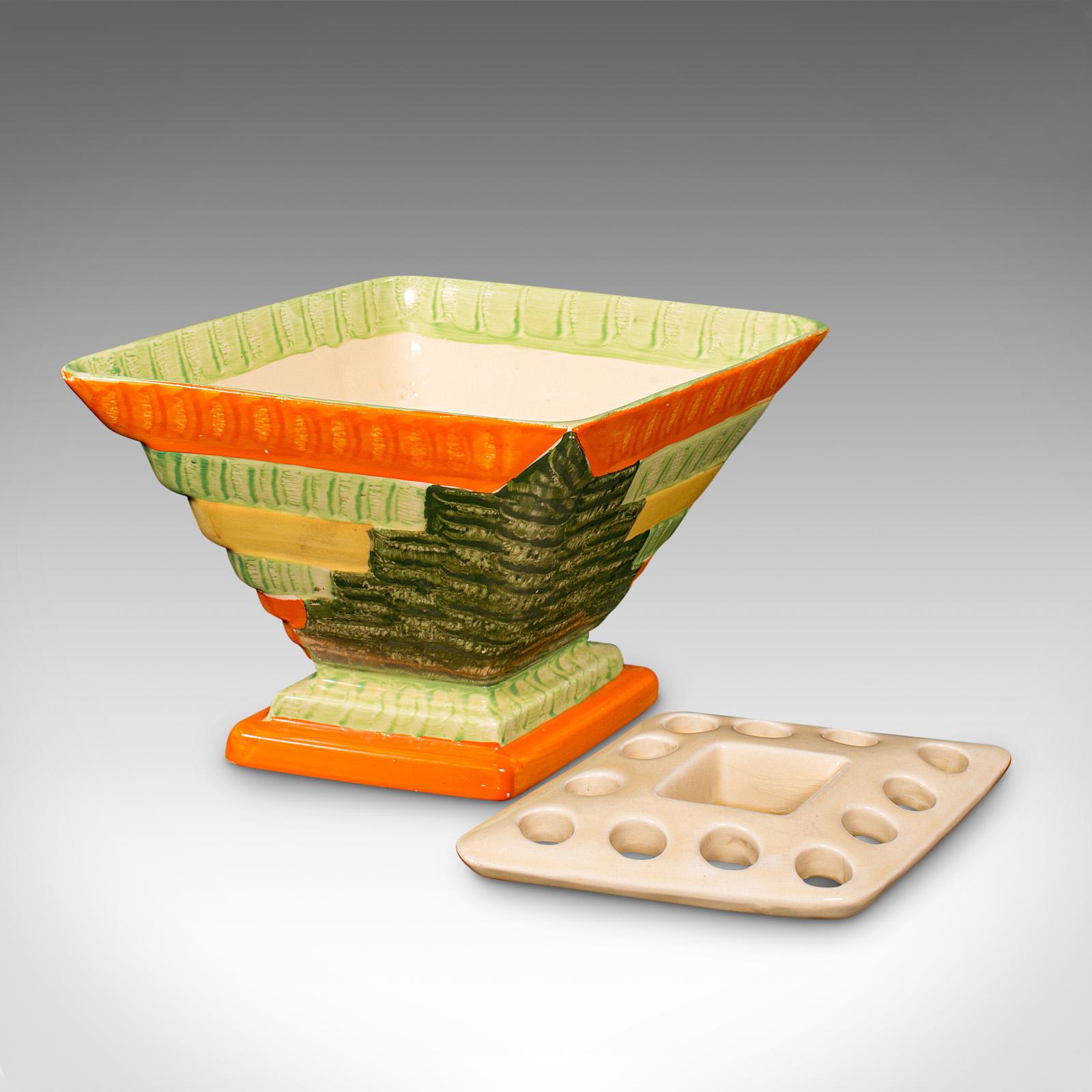 
Dies ist eine Vintage-Vase für Trockenblumen. Eine englische, handbemalte, dekorative, rautenförmige Keramikkanne aus der Zeit des Art déco, um 1930.

Unverwechselbare diamantene Form, mit einer lebhaften Farbpalette
Zeigt eine wünschenswerte