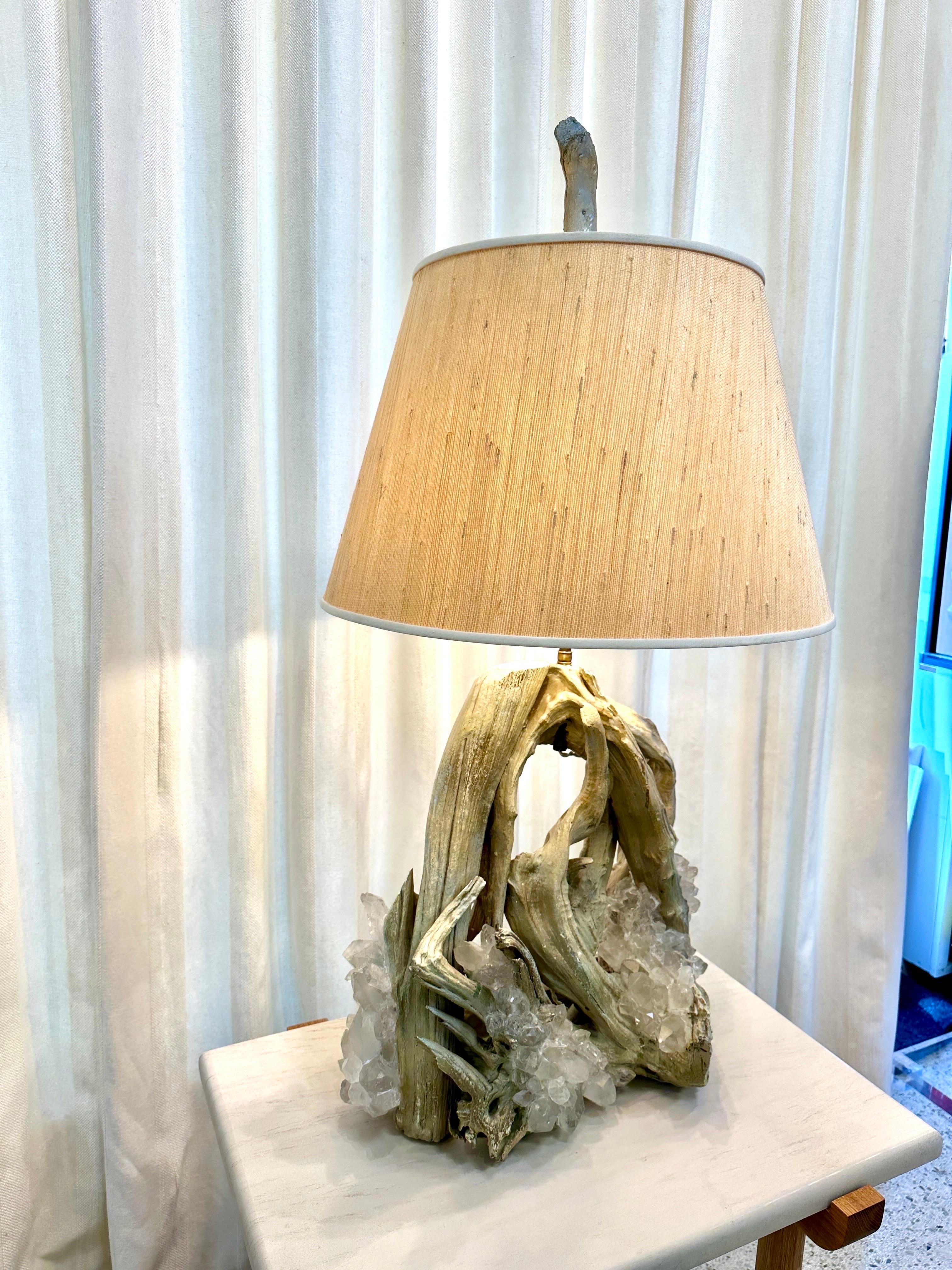A wonderful organic large driftwood lamp with many clear quartz encrustations embedded through the lamp.  When the light reflects off the crystals, it is beyond beautiful.  The lamp has bronze hardware, double cluster sockets and has been rewired