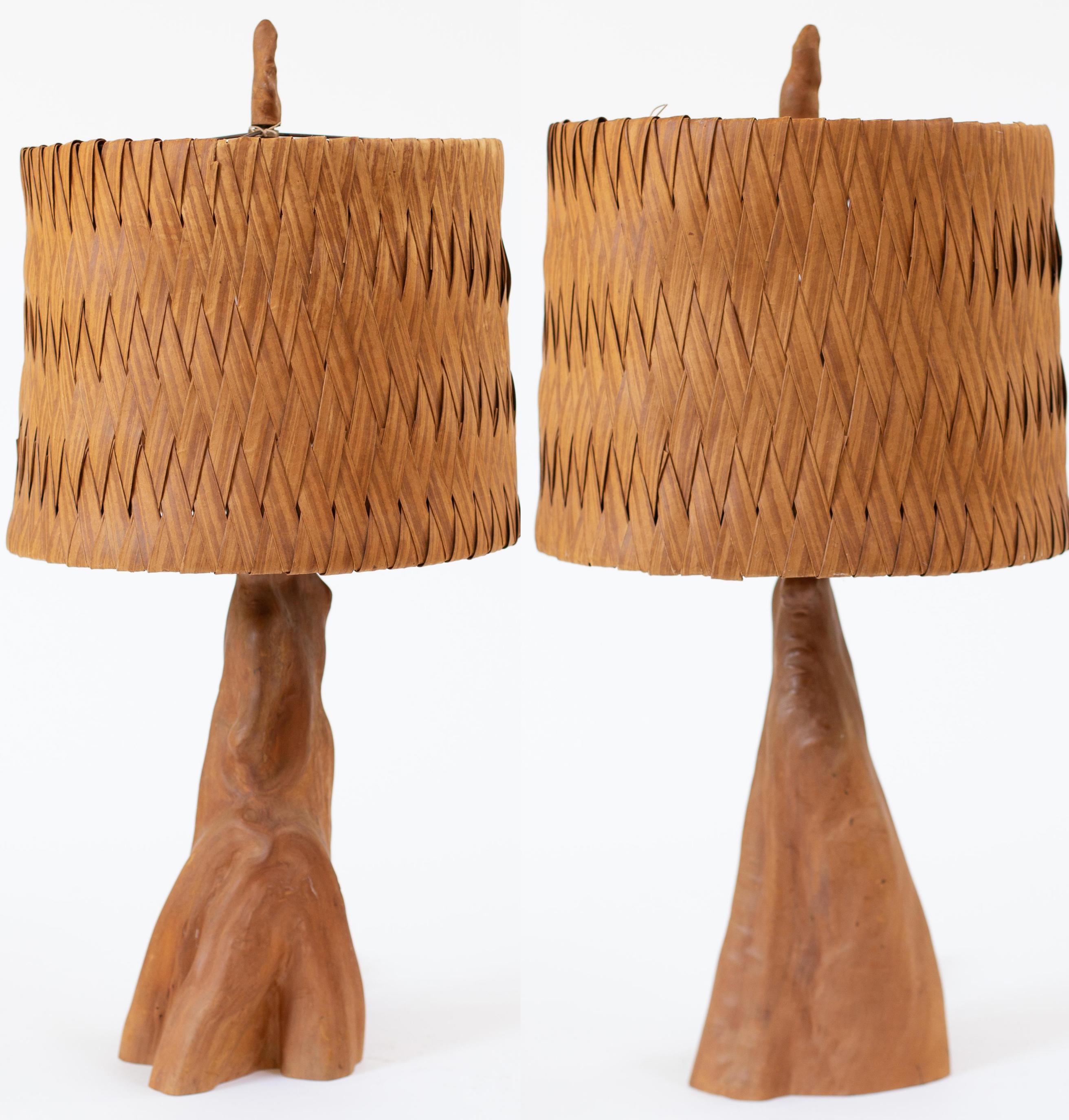 Beautiful vintage table lamps made from gnarled driftwood, appearing to be teak. Wood has reddish-gold undertones, and original high quality woven lamp shades. Original driftwood finials complete the look. Original wiring is in working