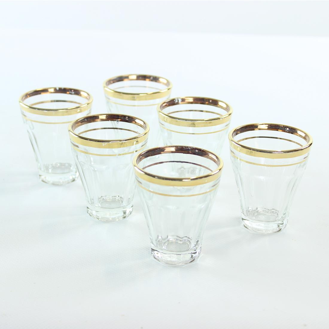 Original and unique set of 6 glasses. Produced in Czechoslovakia in 1960s. The glasses are made out of pressed glass with in pure clear glass. The rim is decorated with gold and handpainted on the glass. Originally this rim was made in a true gold.