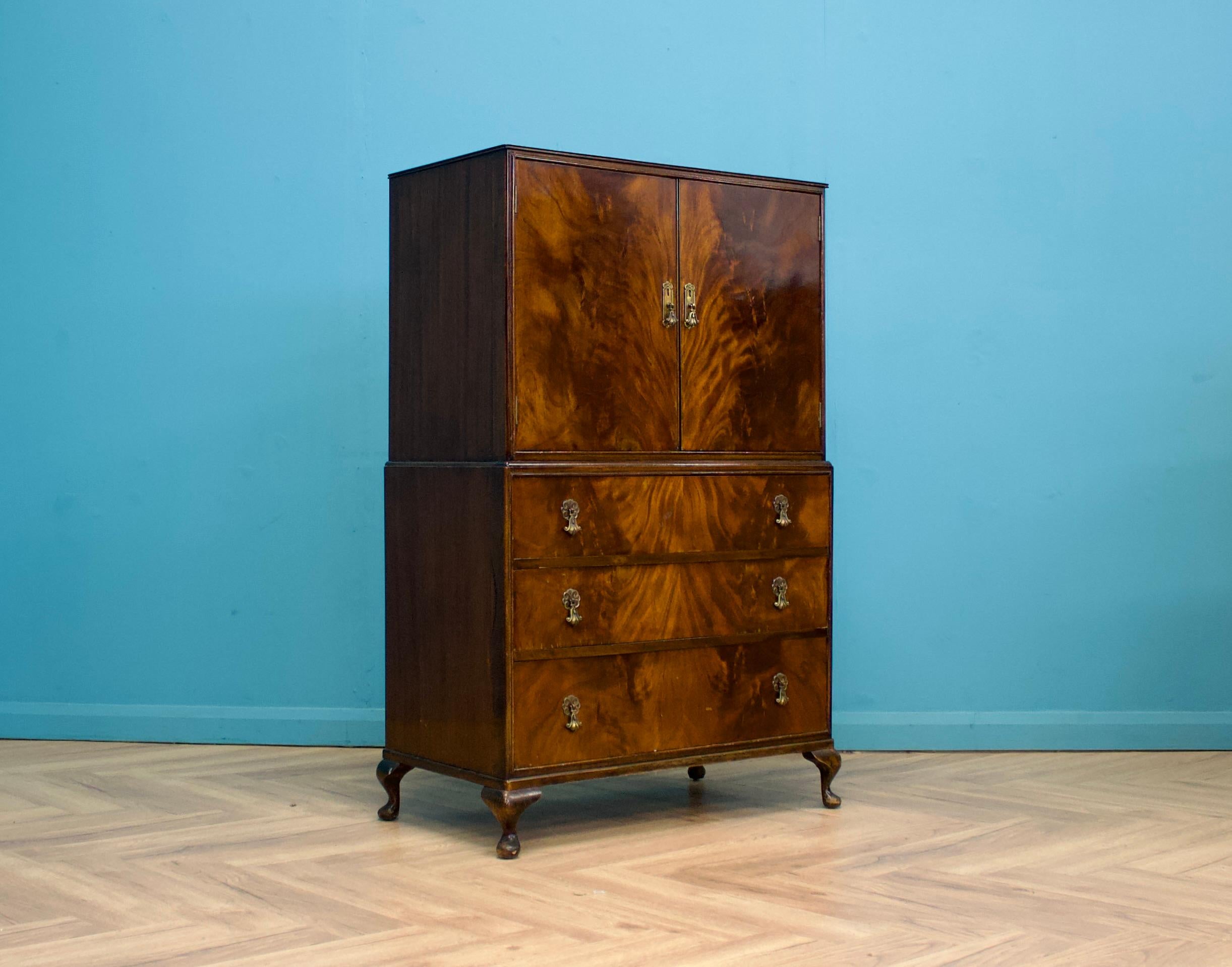 A mid century mahogany Beithcraft drinks cabinet or linen cabinet


There's a cupboard with a mirror back and shelf, along with three drawers.