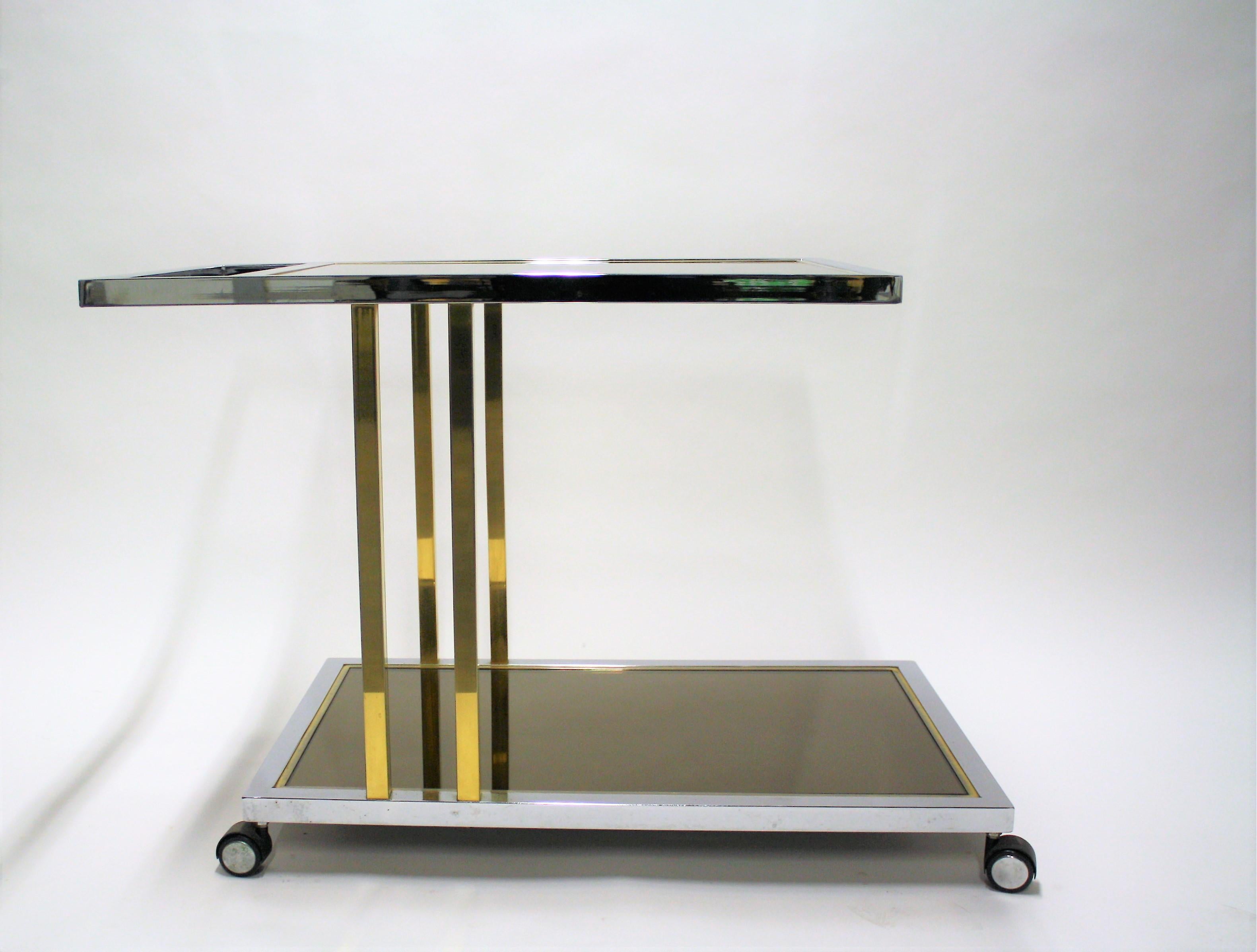 Vintage drinks trolley by Belgo Chrome.

This two-tier cart consists of a smoked glass top and a mirrored glass lower shelve and is made of brass and chrome.

Polished brass and chrome.

Good condition, minor scratches on the glass.

1970s,