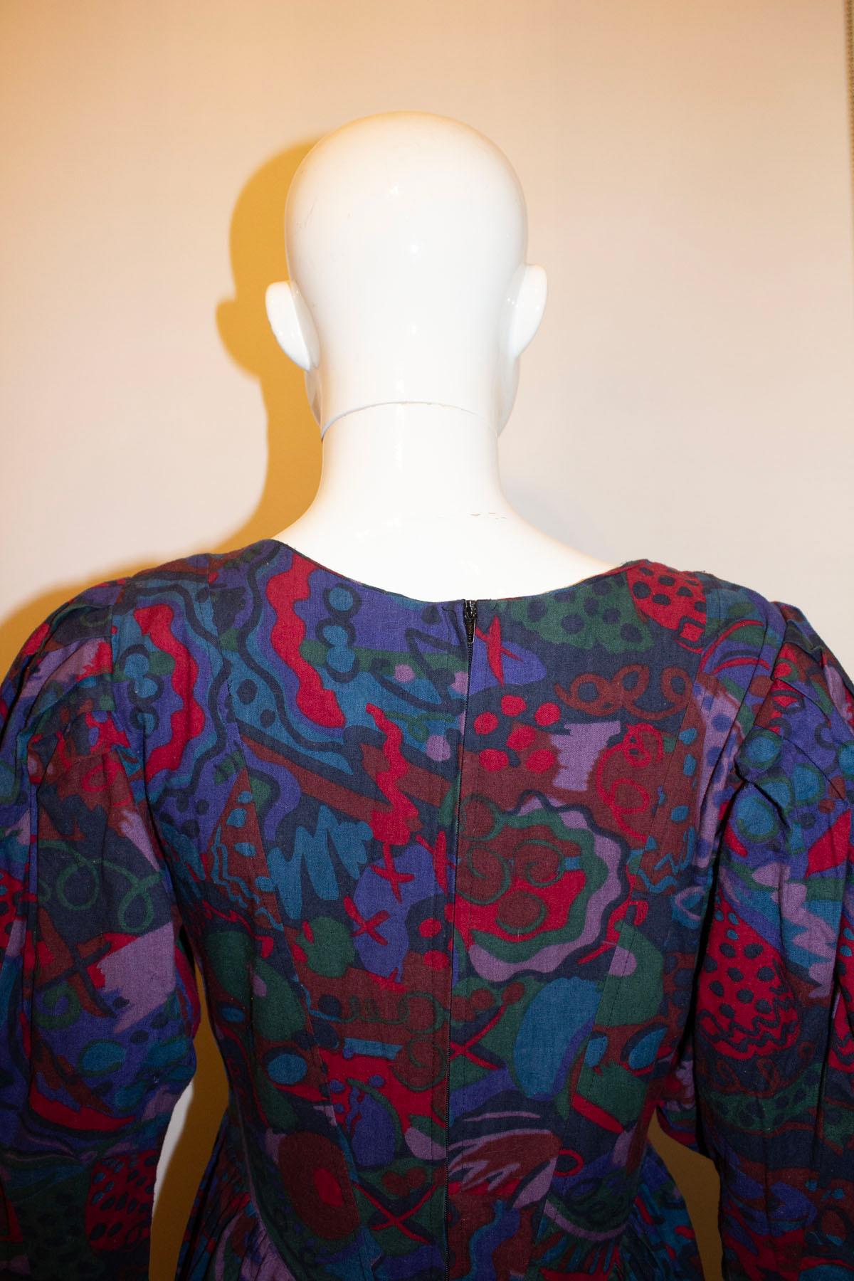 A wonderful and easy to wear vintage multi colour dress by Droopy and  Browns. Dating from the 1980s, the dress has a button front, full sleaves with button cuff and gathering at waist level. It has a back zip opening and the original shoulder