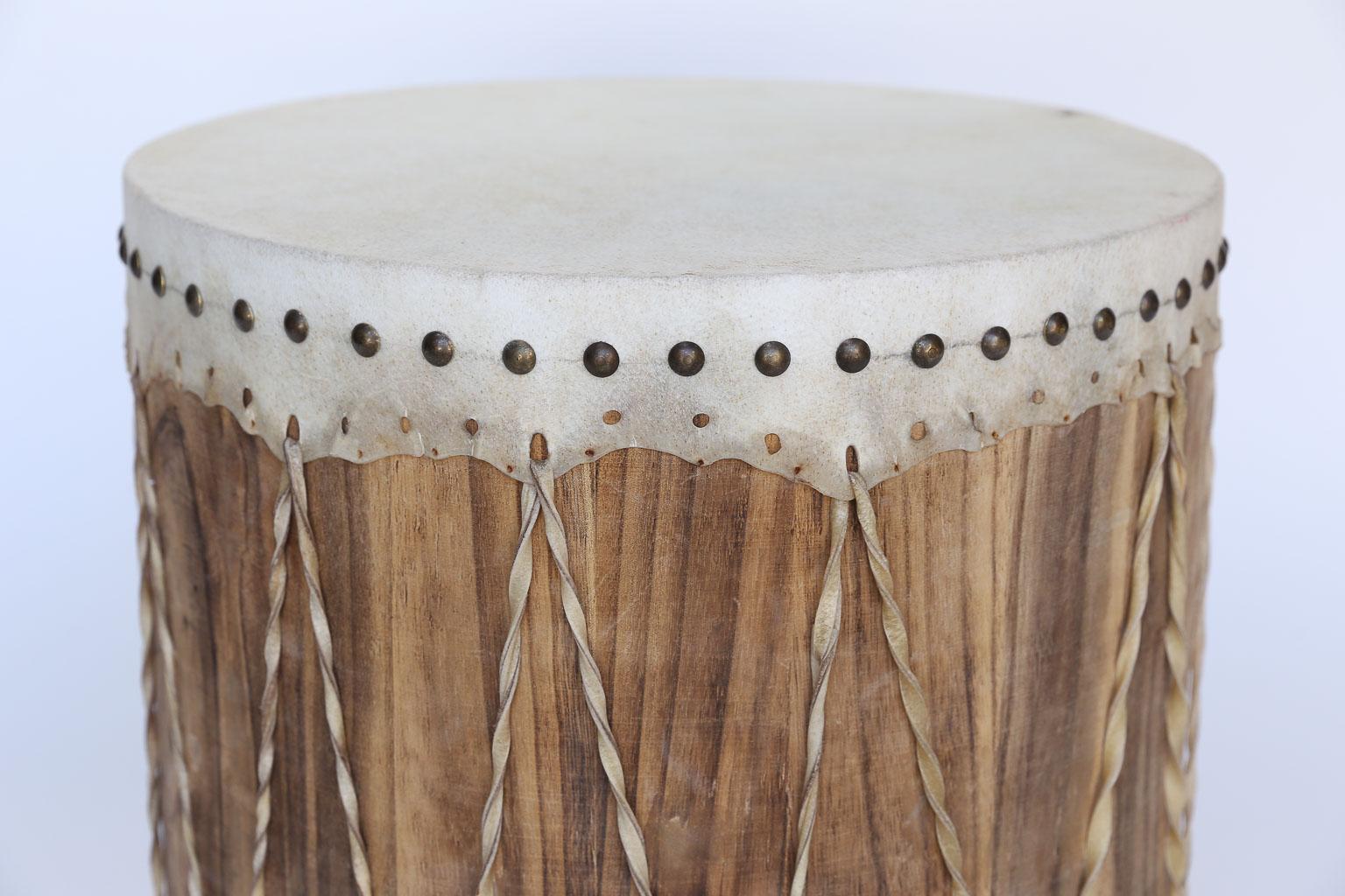 Found in England this vintage drum will add texture and conversation to your room. With a taupe leather top and bottom, the drum is finished with twisted straps and brass nail heads and could easily serve as an end or side table. Beat to your own