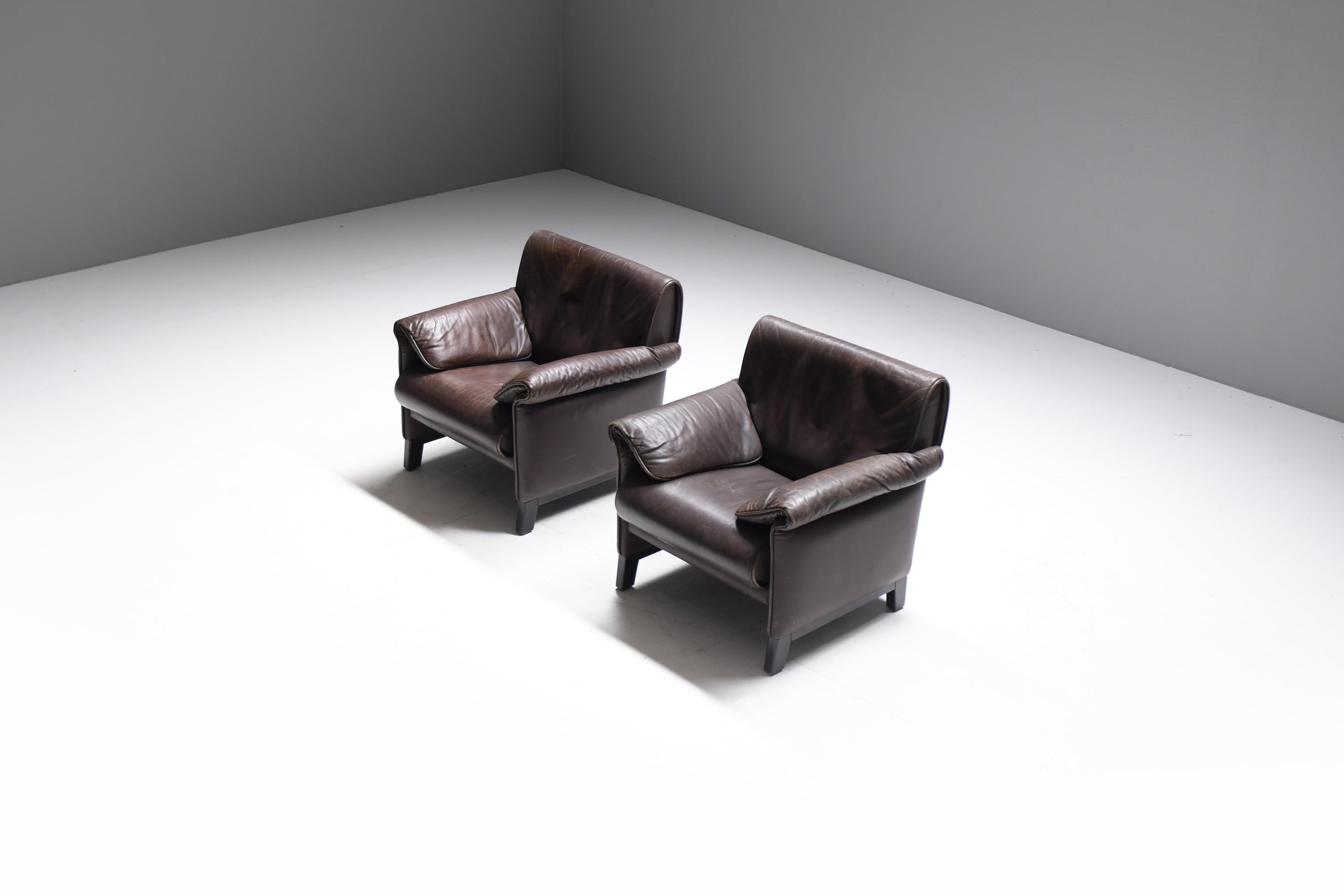 Elegant pair of De Sede 'DS-14' armchairs in a patinated dark brown leather and with a black lacquered wooden base.
Designed in 1989 by Team De Sede and manufactured between 1989 and 1997. 

With a fascinating history of sixty years behind, the