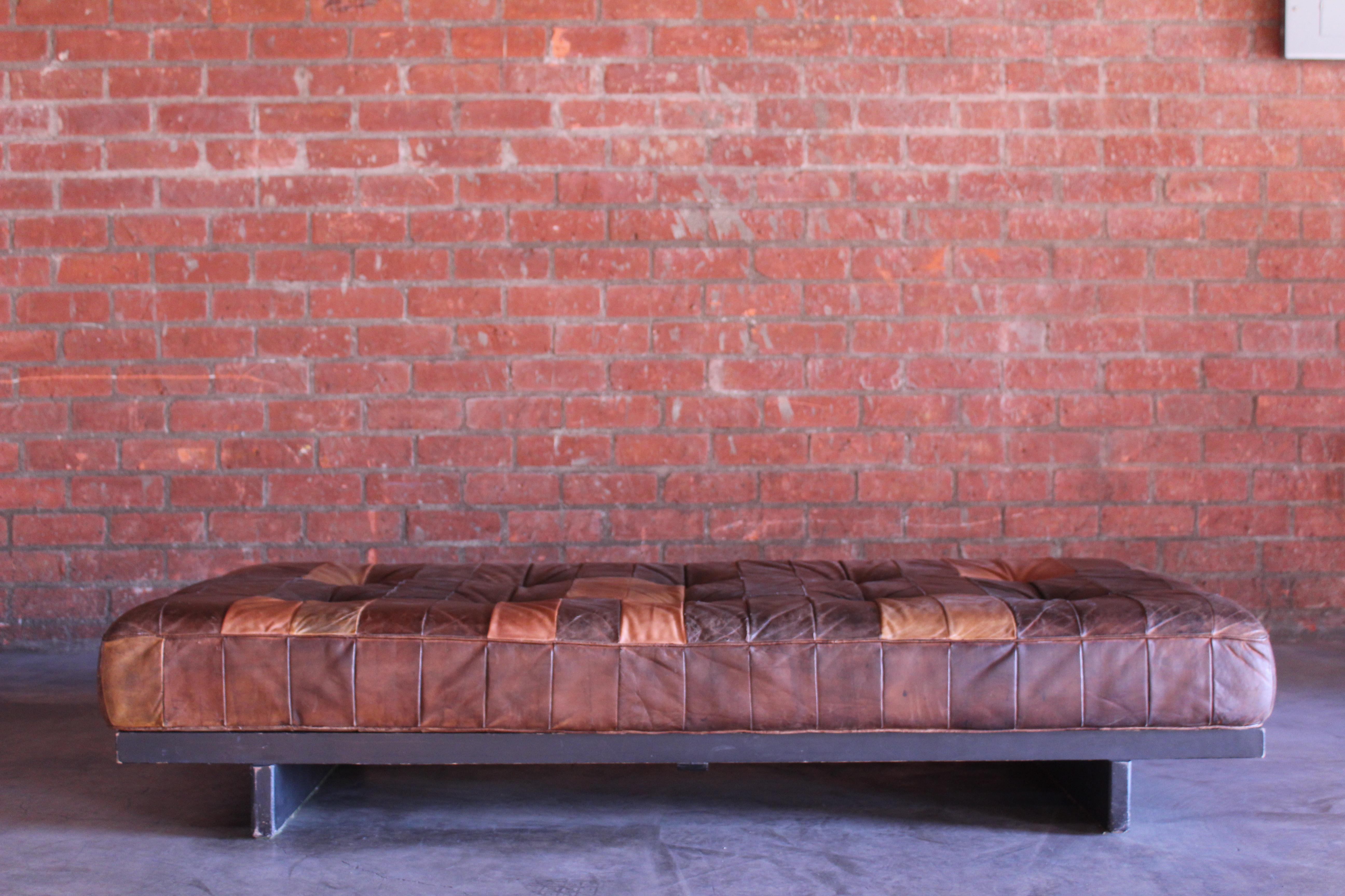 Vintage patchwork leather daybed by De Sede, Switzerland, 1960s. Sits on an ebonoized walnut wood base. In overall good original condition with age appropriate wear. The leather has a nice patina, the wood base shows some wear on the finish.