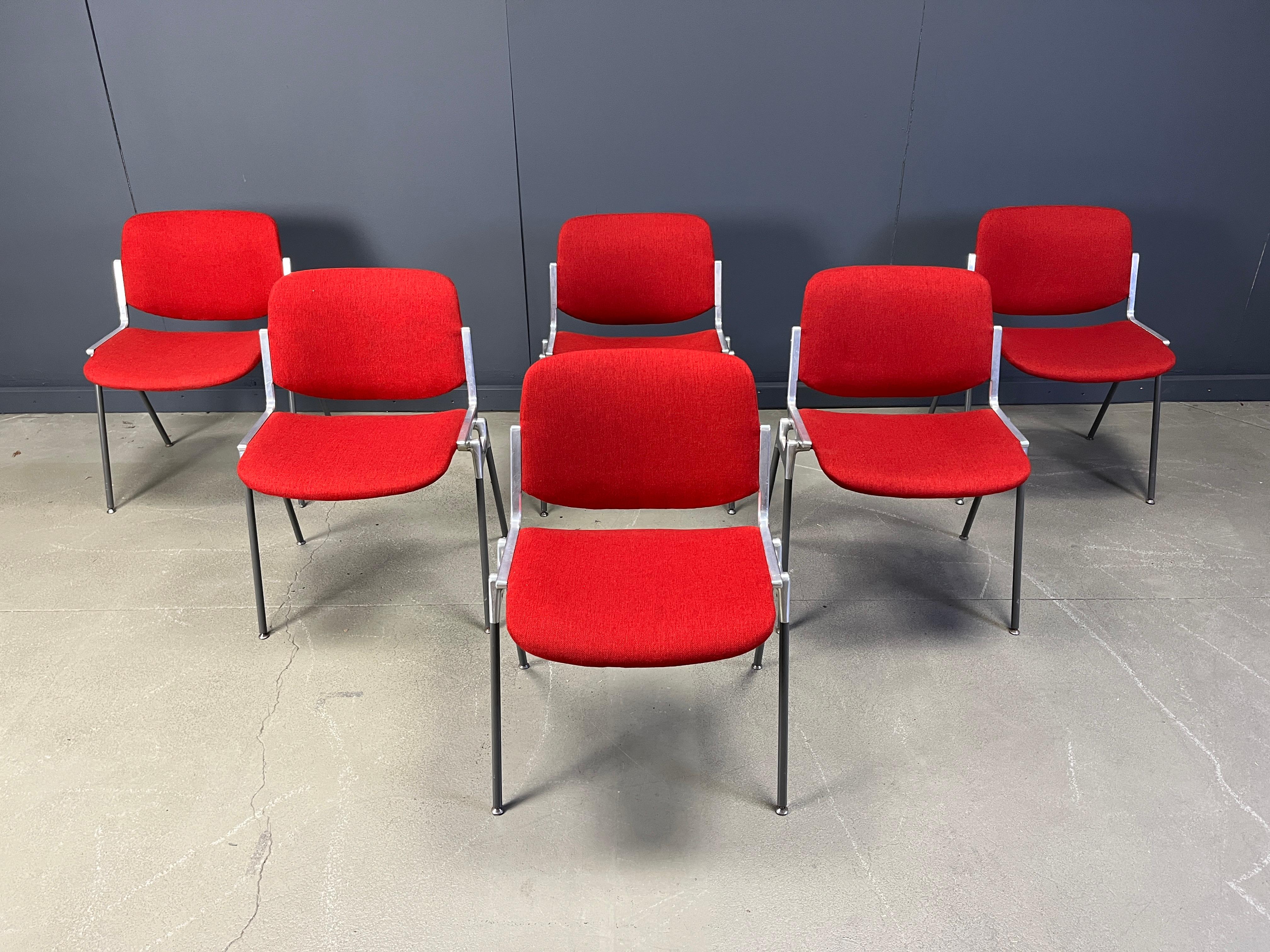 Step back into the elegance of the 1970s with this exquisite set of six DSC 106 Side Chairs, designed by the renowned Giancarlo Piretti for Castelli. These chairs are a testament to timeless design, featuring a striking red textile upholstery that