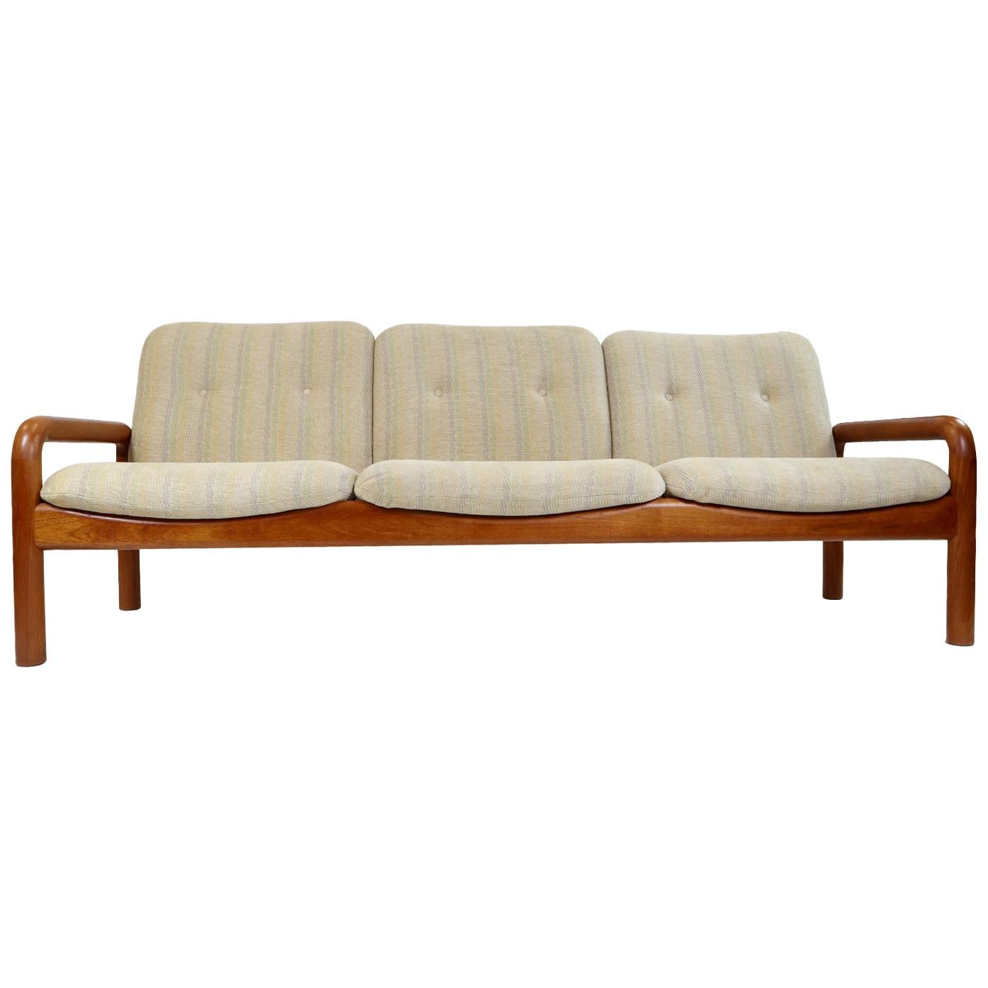 Vintage Danish modern sofa by DScan. The solid teak wood frame supports the light beige upholstered cushions. Quality is in the details with the choice of durable, attractive teak wood and plush fabric. The light beige fabric has a soft, almost