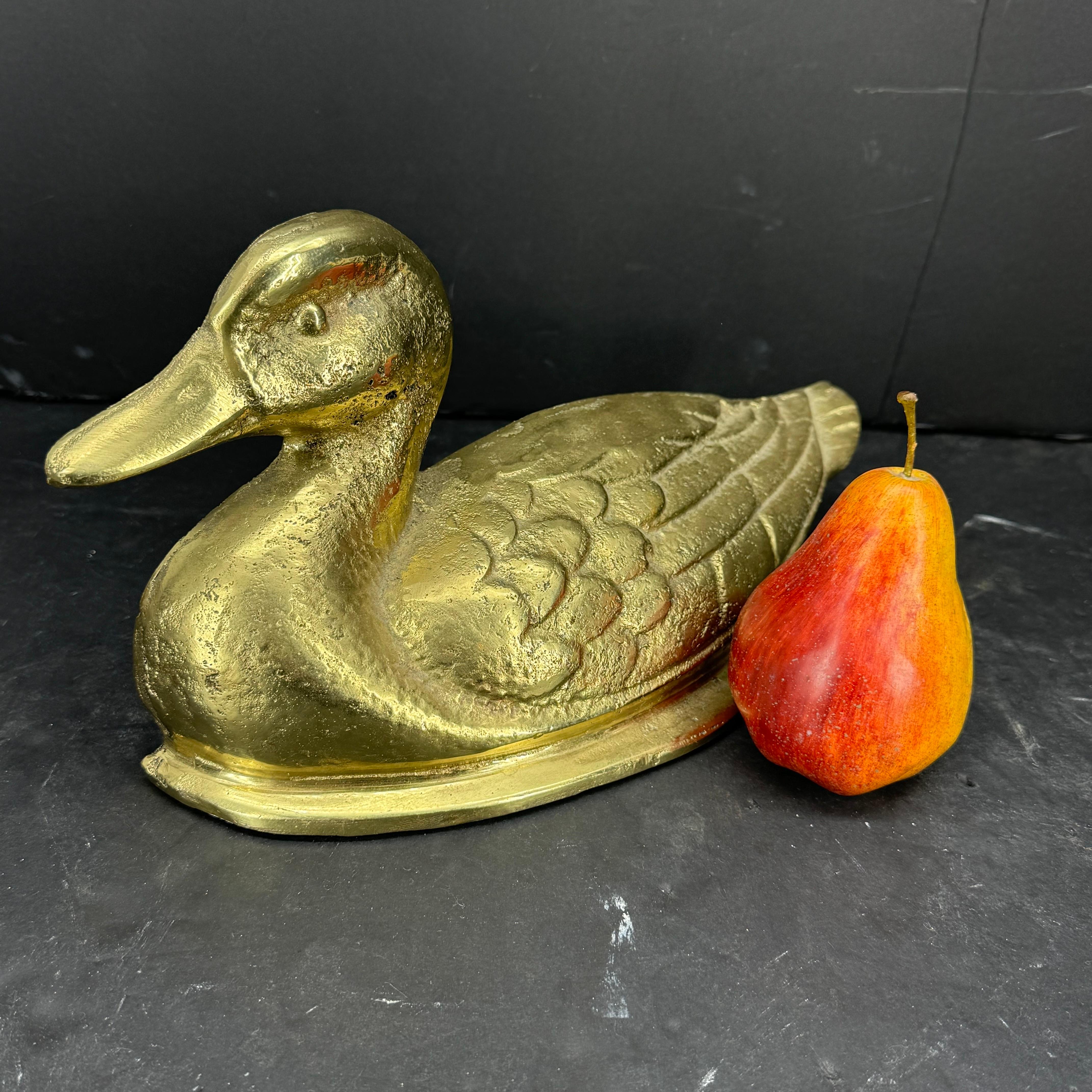 Gran escultura de hierro fundido de un pato en latón macizo. Este gran tope de puerta es a la vez forma y función, puede utilizarse como tope de puerta y como pieza escultórica en la repisa de una chimenea, así como estantería de libros en una
