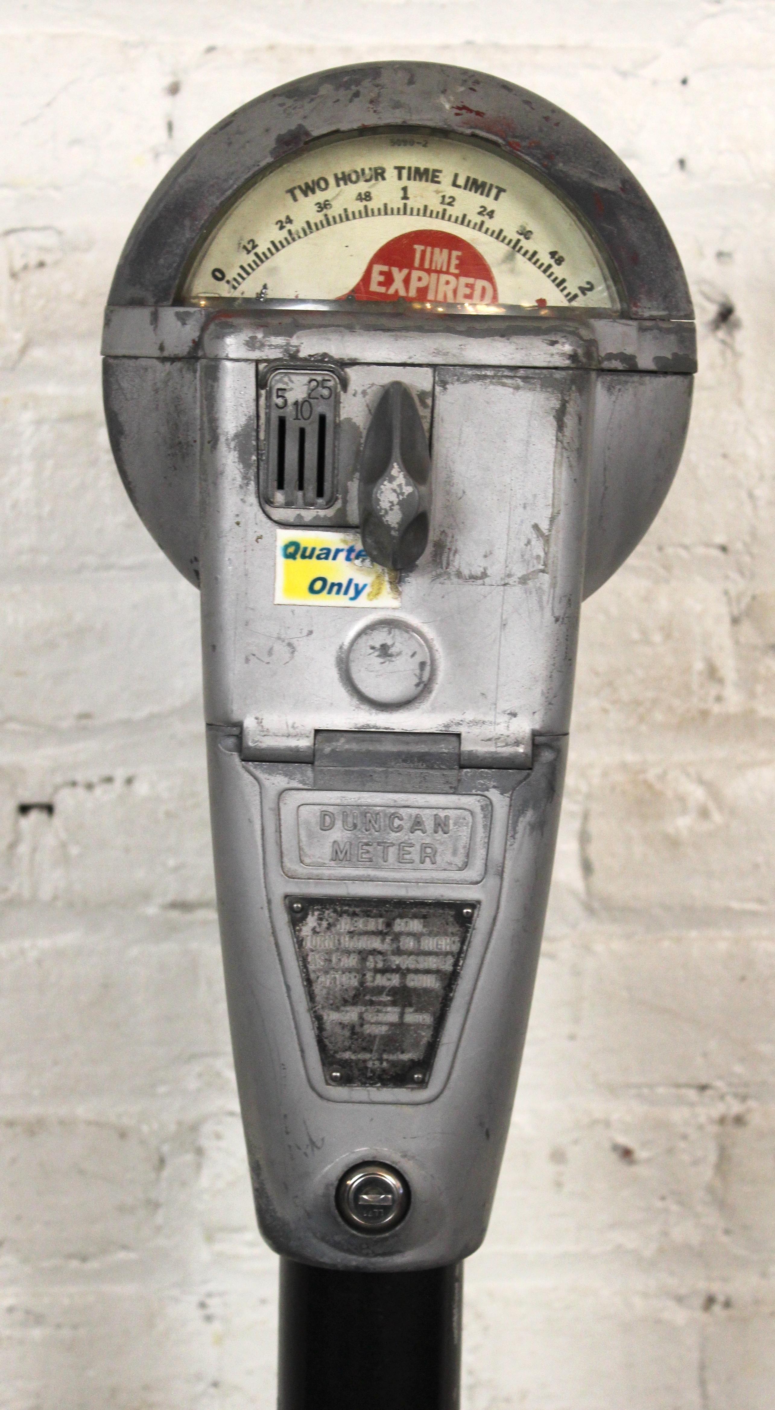 Standing parking meter made by Duncan Miller of Chicago. Featuring three coin slots, 'time expired' and 'violation' flags, and set on a metal pedestal base. Please confirm item pickup location (Brooklyn or New Jersey) with seller.