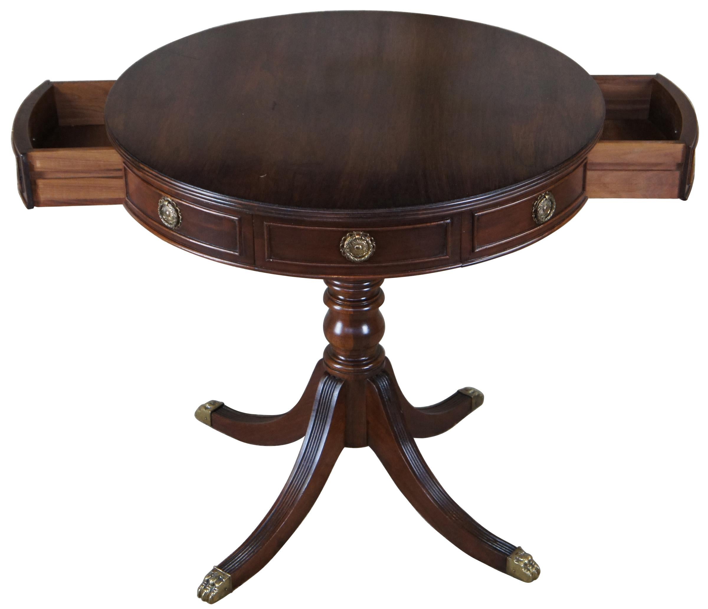 Sheraton style mid 20th century mahogany drum table. Features a round top with fluted edge and two drawers over a turned baluster base leading to four saber legs. 
 