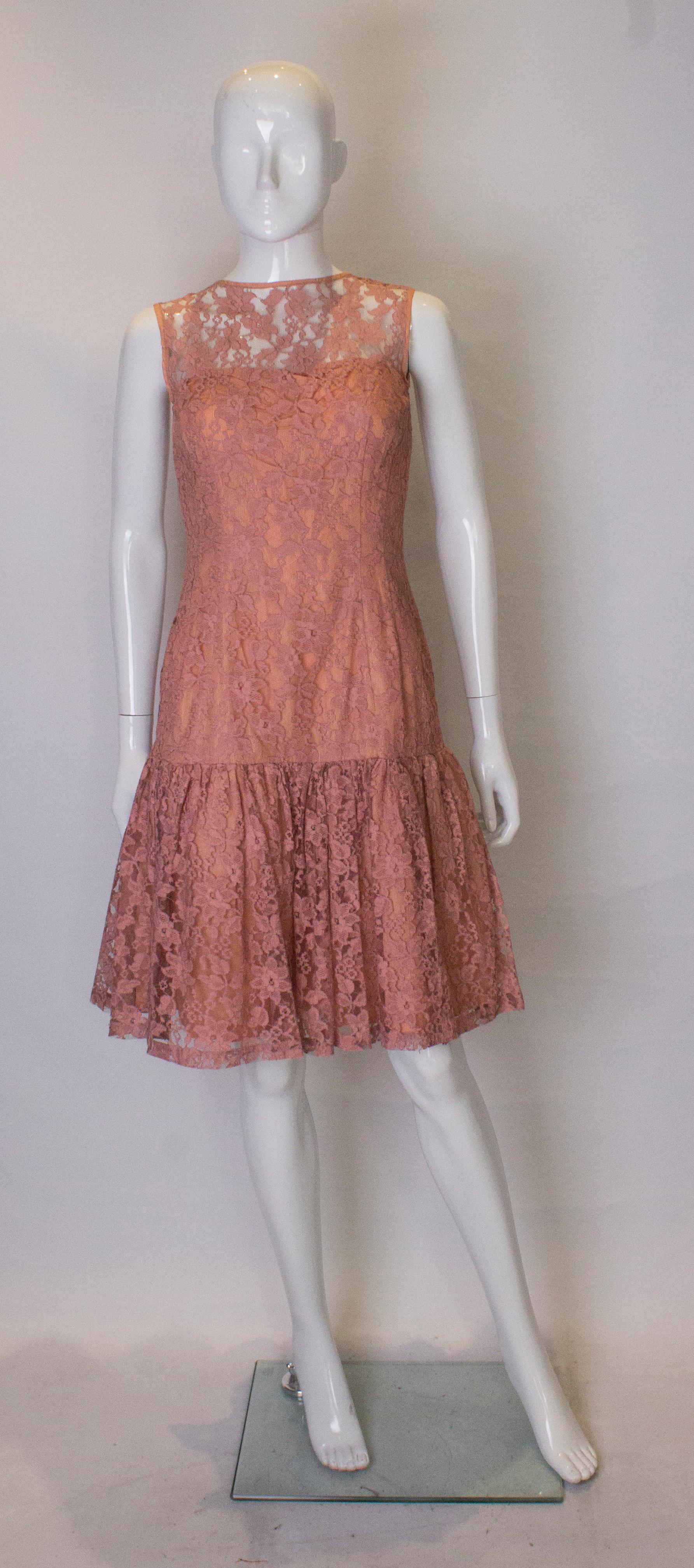 A pretty dusty pink  lace vintage  cocktail dress . The has a drop waist , a v backline, central back zip and is fully lined. 