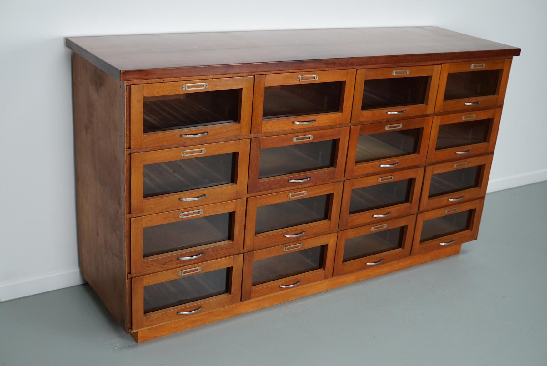 This haberdashery cabinet was produced during the 1950s in the Netherlands. It features 16 large drawers with glass fronts and chrome handles. The interior dimensions of the drawers are: DWH 39 x 36.5 x 17 cm.
