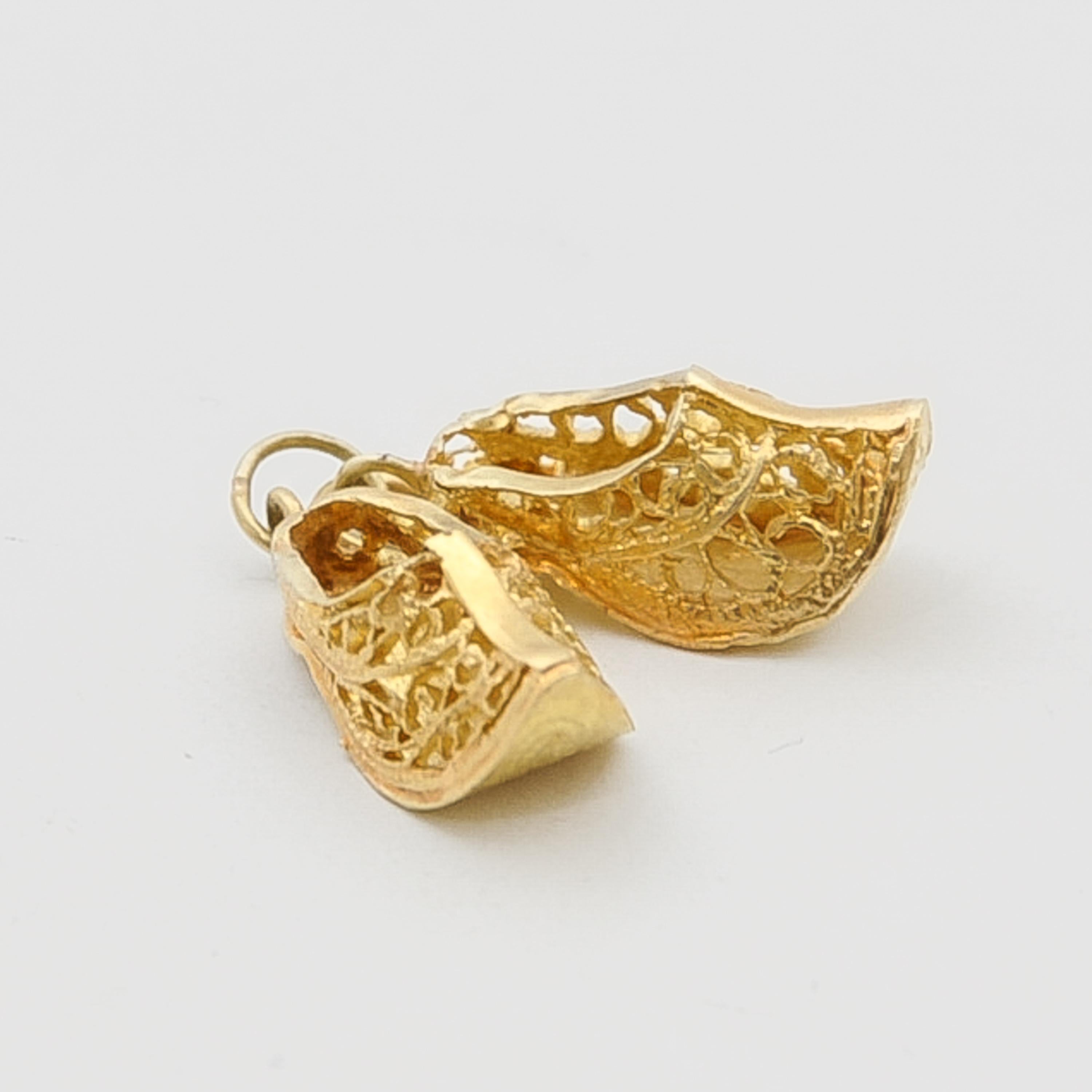 A beautiful pair of vintage three-dimensional filigree Dutch clogs charm pendant. These clogs are nicely detailed with filigree and made in 14 karat yellow gold. The Netherlands is the country of tulips, windmills and clogs. These Dutch icons, are