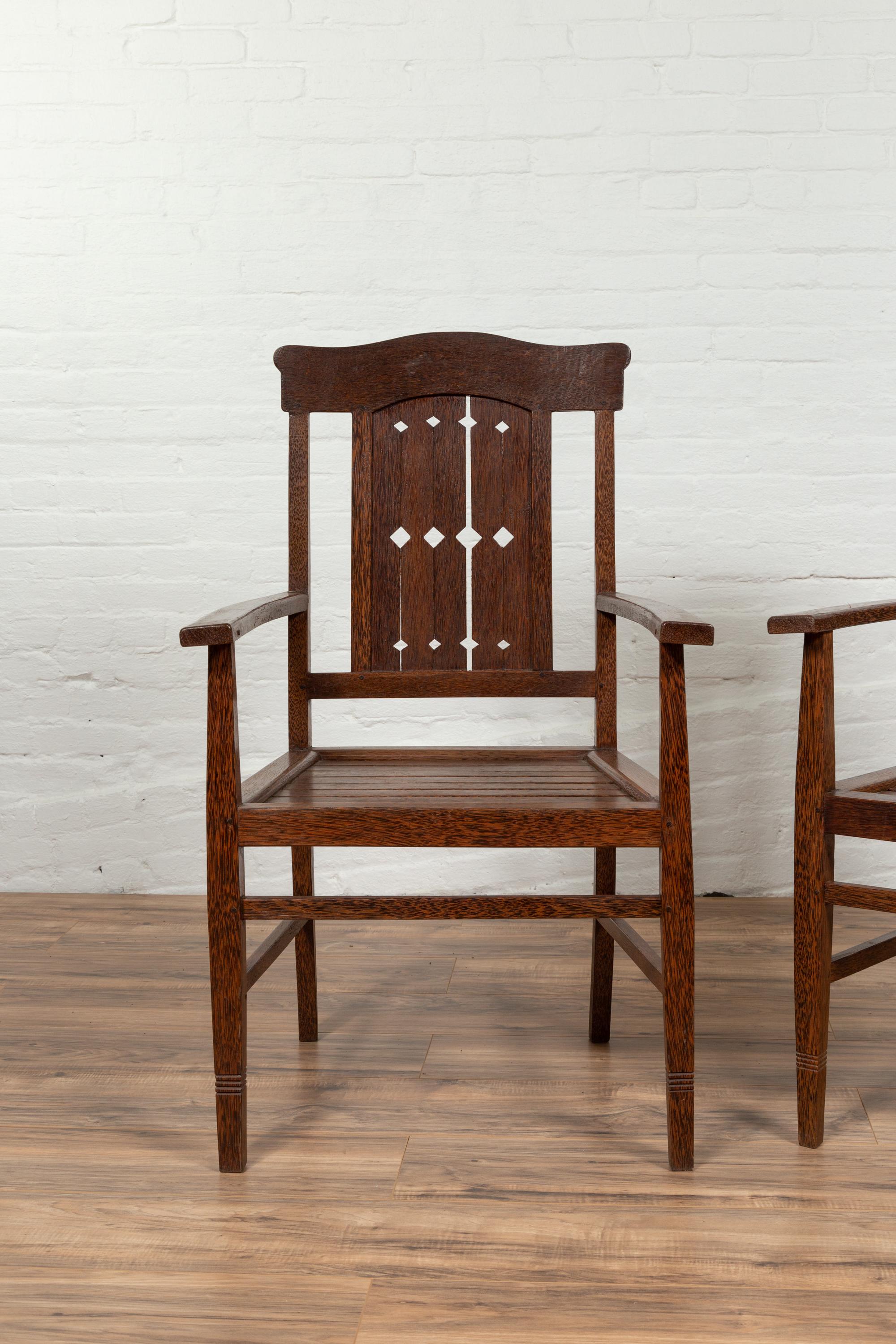 Poltrone coloniali olandesi vintage della metà del XX secolo, con binario superiore a forma di cofano e doghe in legno su schienale e seduta. Attualmente sono disponibili tre sedie, ognuna con lievi variazioni, il cui prezzo è venduto singolarmente.