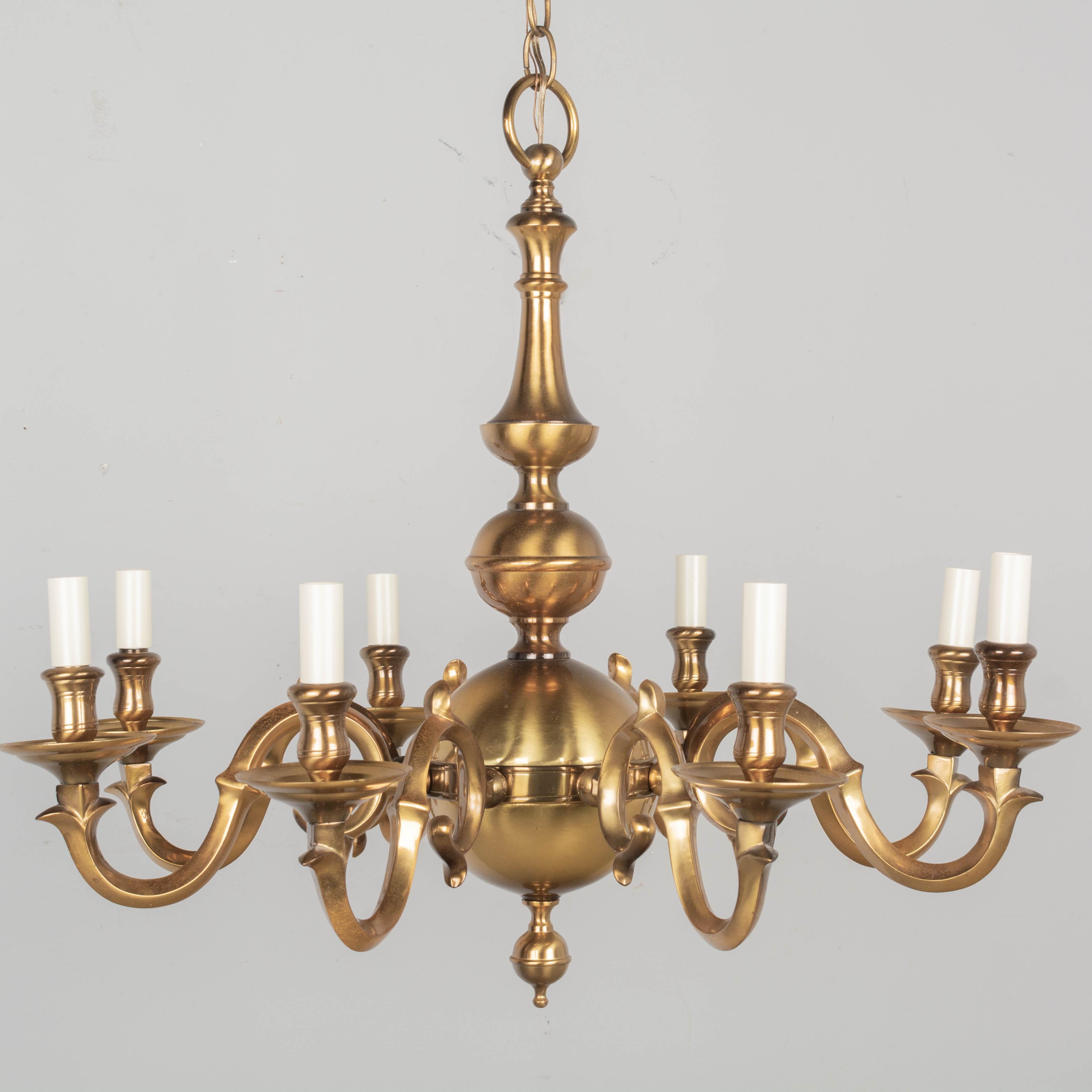 A vintage Dutch Colonial eight-light chandelier with large brass sphere. Good quality heavy solid brass. In working condition with new candle covers. Circa 1980s. 
Dimensions: 26.5