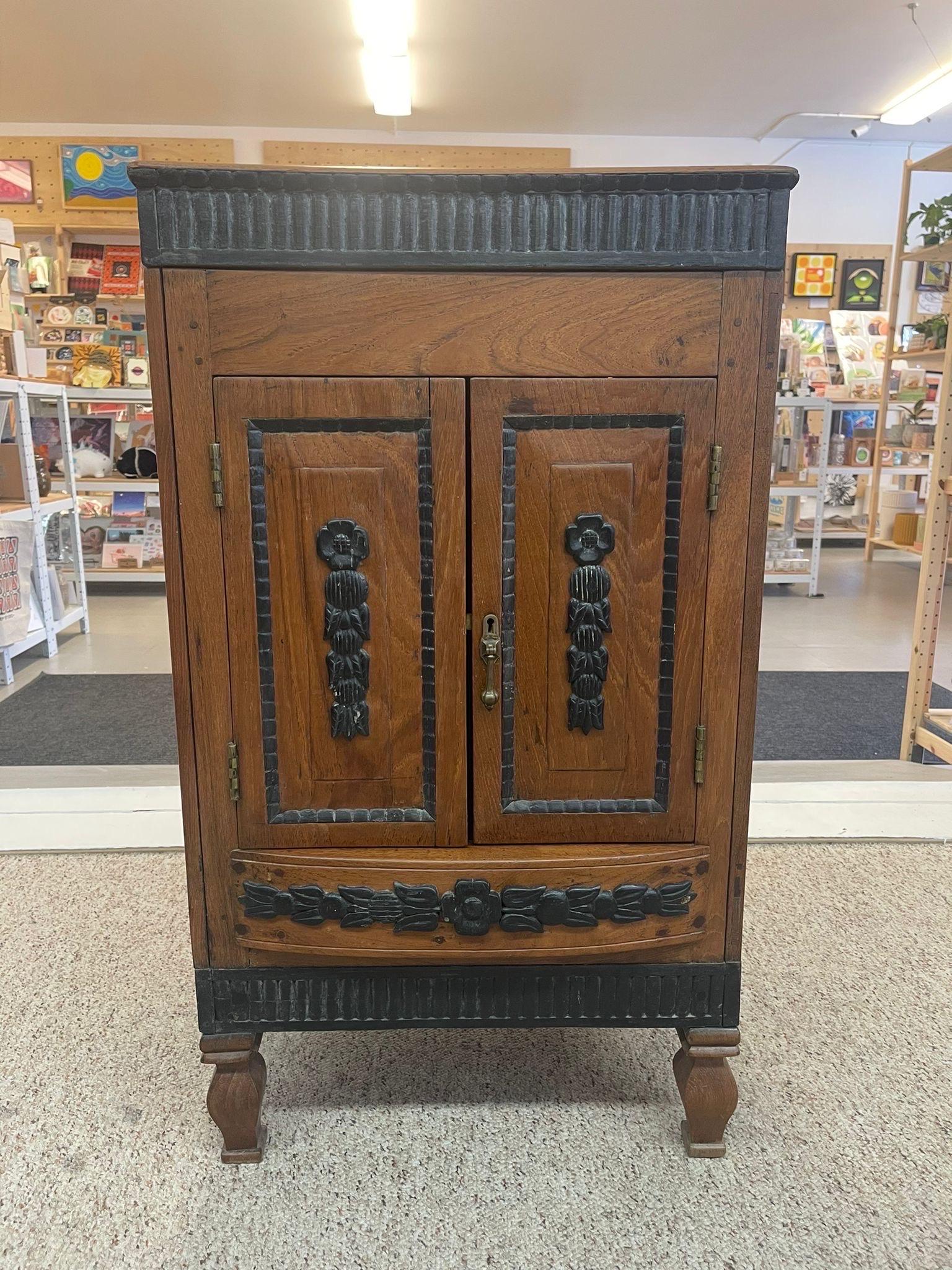This Dutch colonial cabinet opens from the top, front and back as shown. Every side is enhanced with Carved wood Floral detailing and lining. Carved wood legs. Hardware is original. Vintage Condition Consistent with Age as Pictured.

Dimensions. 21