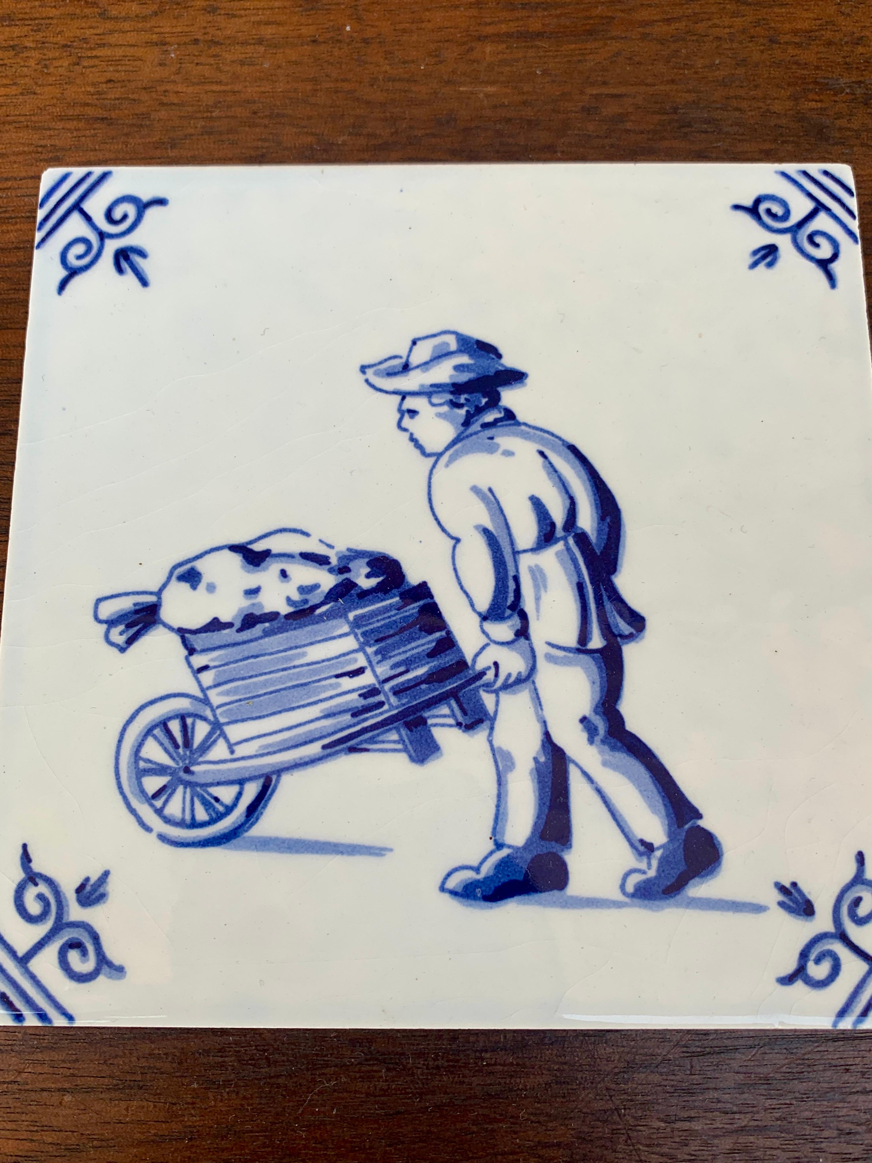 Olandese Mattonella olandese vintage di Delft in bianco e blu con un ragazzo e un carretto in vendita
