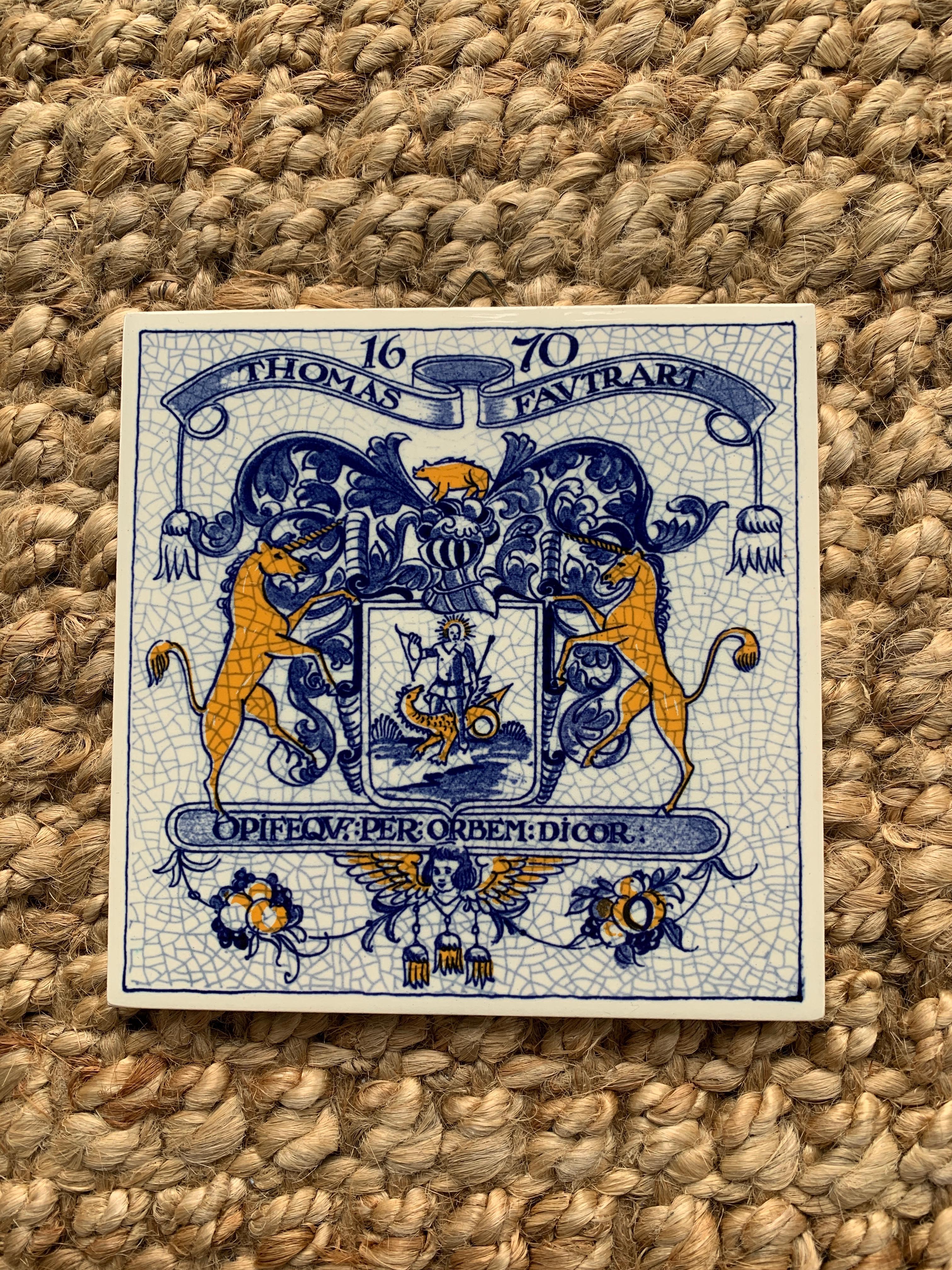 Magnifique carreau de céramique peint à la main en bleu et blanc, de style Delft ou provincial français, représentant une armure et un casque de chevalier stylisés, avec un rhinocéros au-dessus d'un bouclier avec deux licornes se faisant face. À