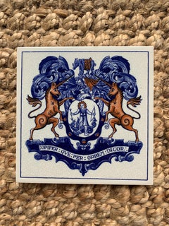 Azulejo vintage holandés de Delft azul y blanco con un escudo heráldico