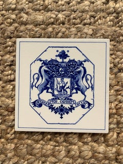 Azulejo vintage holandés de Delft azul y blanco con un escudo heráldico