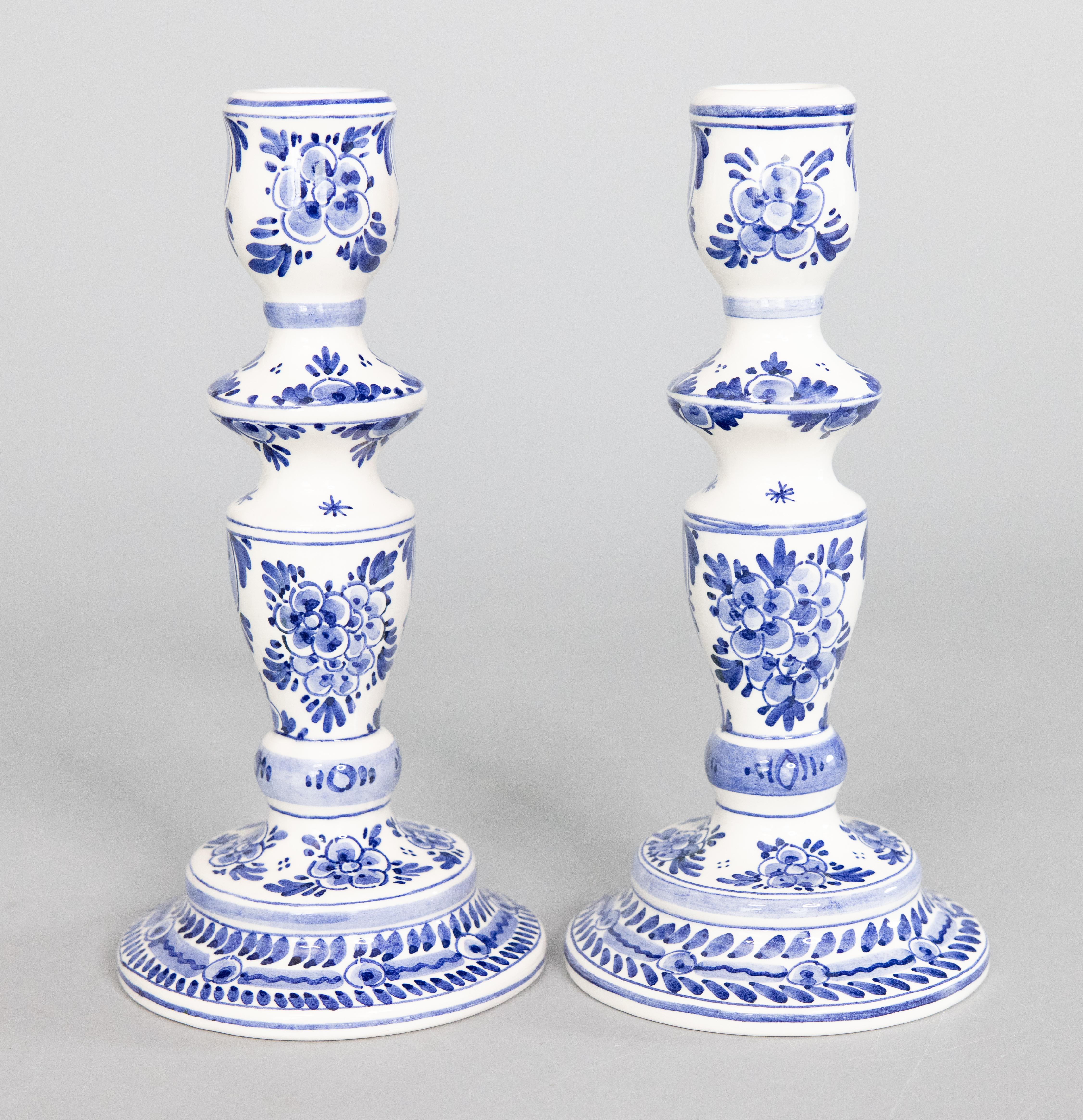 Una bella coppia di candelieri in maiolica olandese di Delft della metà del secolo. Marchio del fabbricante sul retro. Questi raffinati candelieri sono dipinti a mano con un disegno floreale nei tradizionali colori Delft: blu cobalto e
