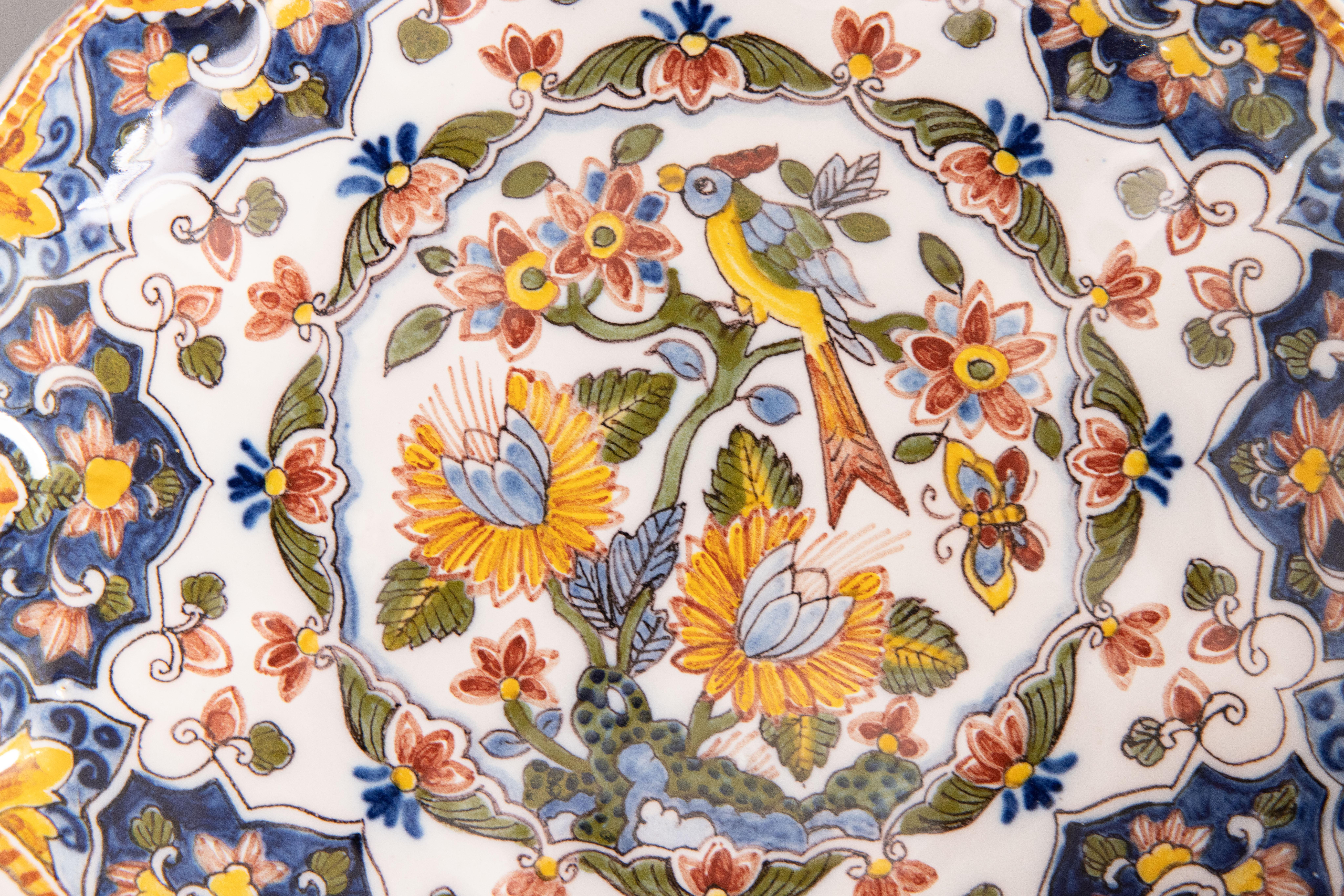 A gorgeous Dutch Delft faience polychrome floral wall plate by Royal Tichelaar Makkum, circa 1940. Maker's mark on reverse. The foot on the back is pierced for hanging. This beautiful plate has a stylish octagonal shape, lovely scalloped design, and