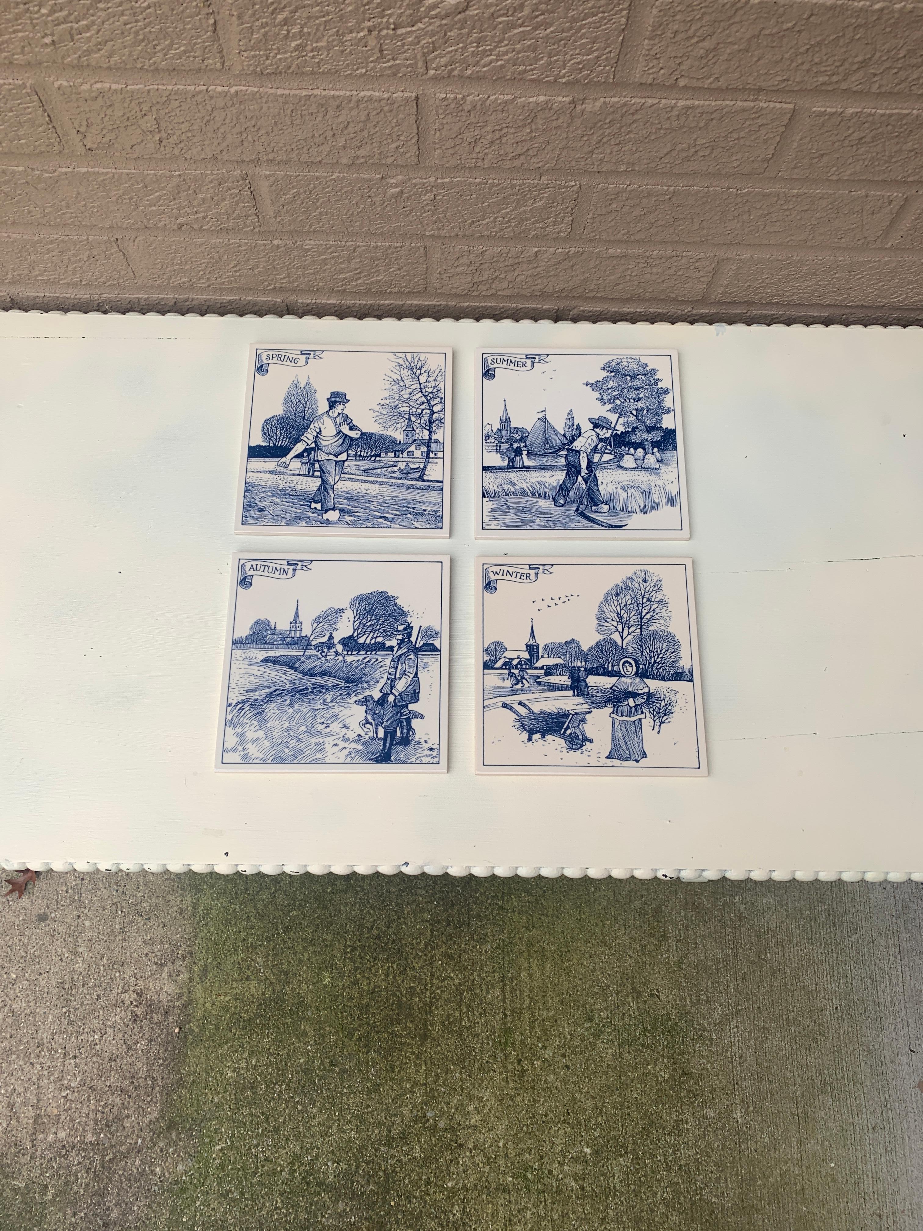 A charming set of four hand painted blue and white Delft ceramic tiles featuring scenes depicting the Four Seasons. These make excellent coasters. They are also ready to hang on a wall, if desired. 

Holland, Circa Mid-20th Century

Measures: 6