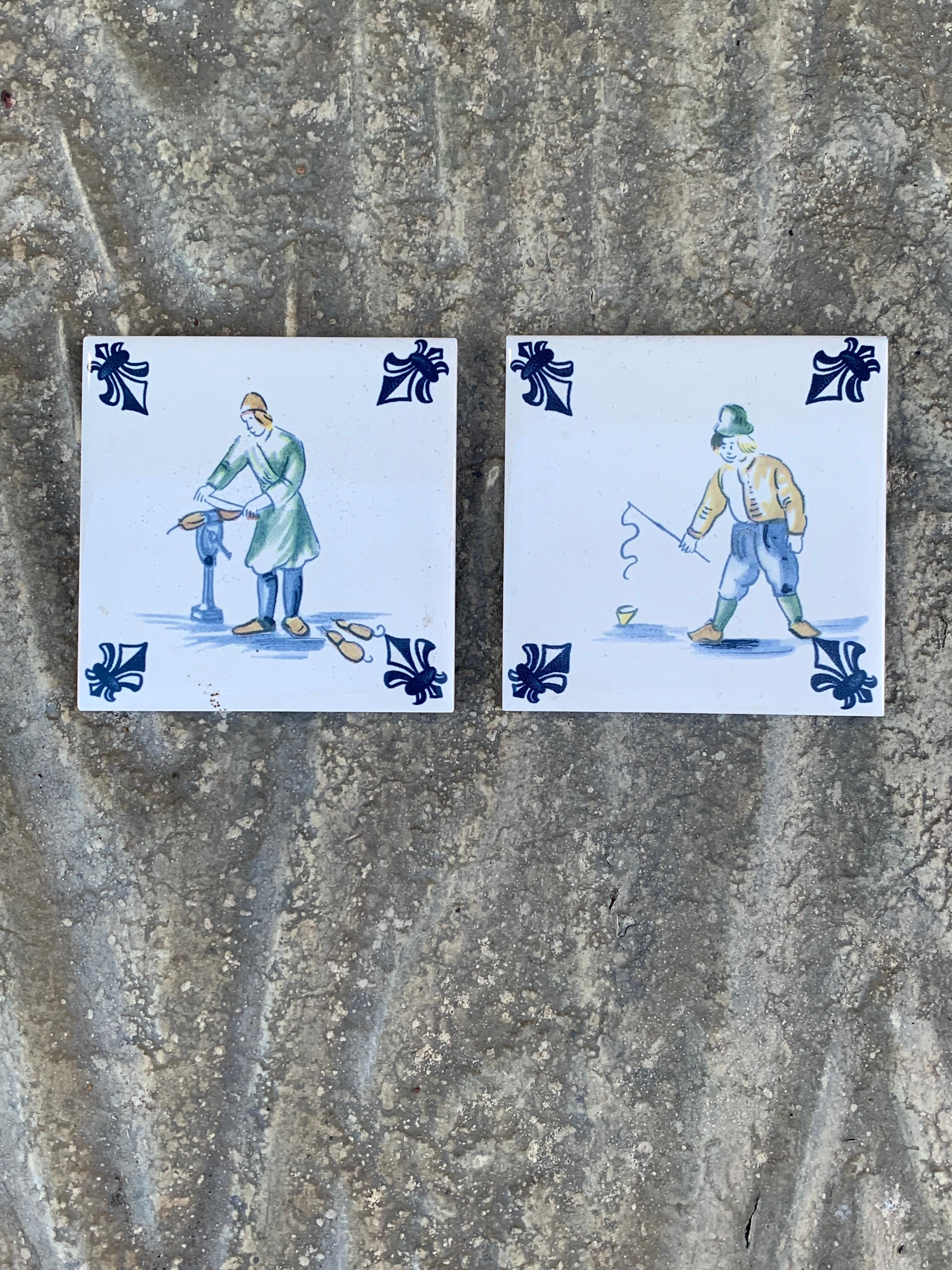 Ein schönes Paar handgemalter blauer und weißer Keramikfliesen im Delft-Stil, die Menschen beim Wurstmachen und Fischen zeigen. Sie eignen sich hervorragend als Untersetzer.

Holland, ca. Mitte des 20. Jahrhunderts

Maße: 3 