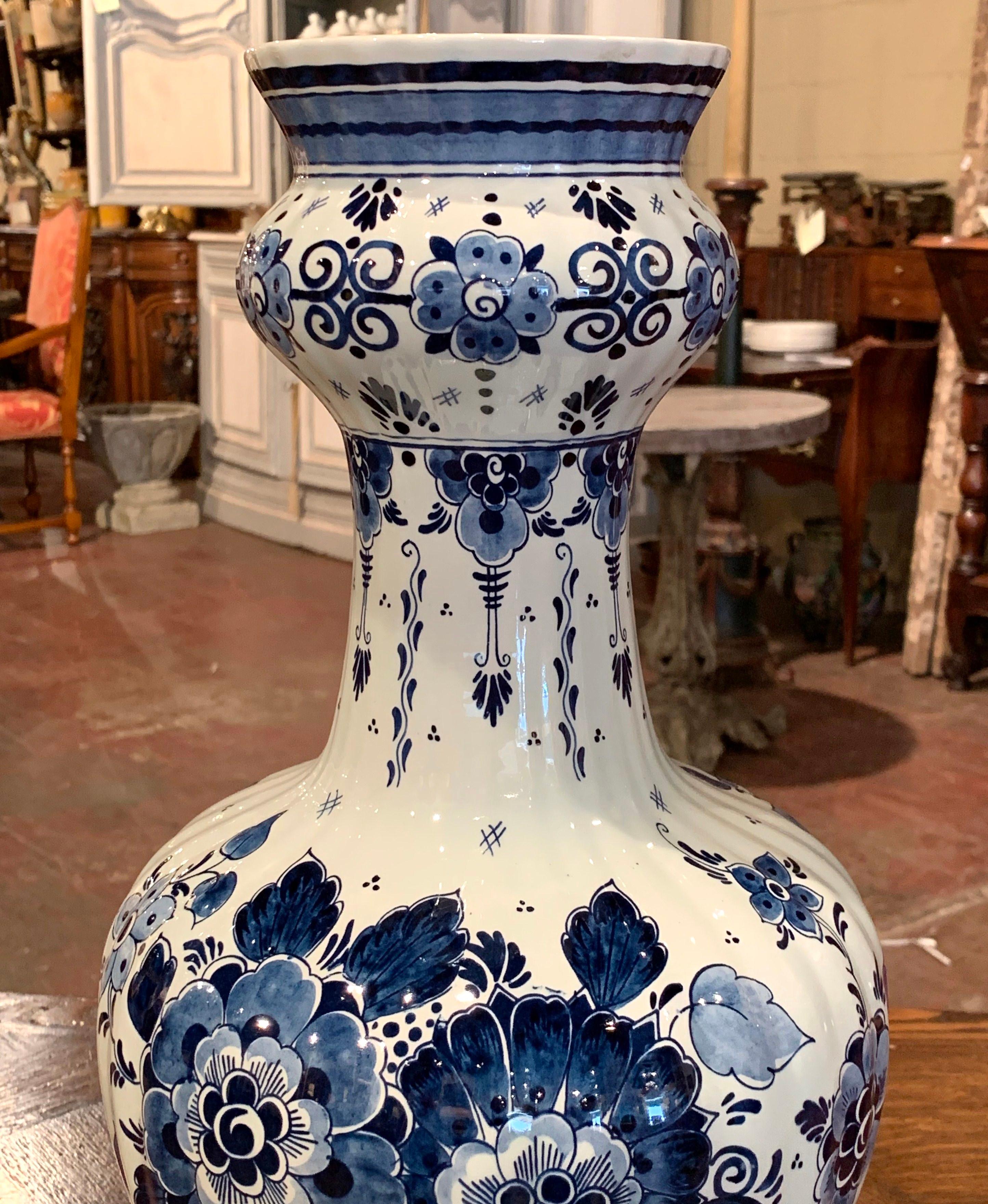 Decorate a mantle or buffet with this tall, ceramic vase from Holland. The vintage, Dutch vase was sculpted circa 1970, yet has the traditional antique Delft style. The ceramic vase is hand painted with signature blue and white floral decor and is