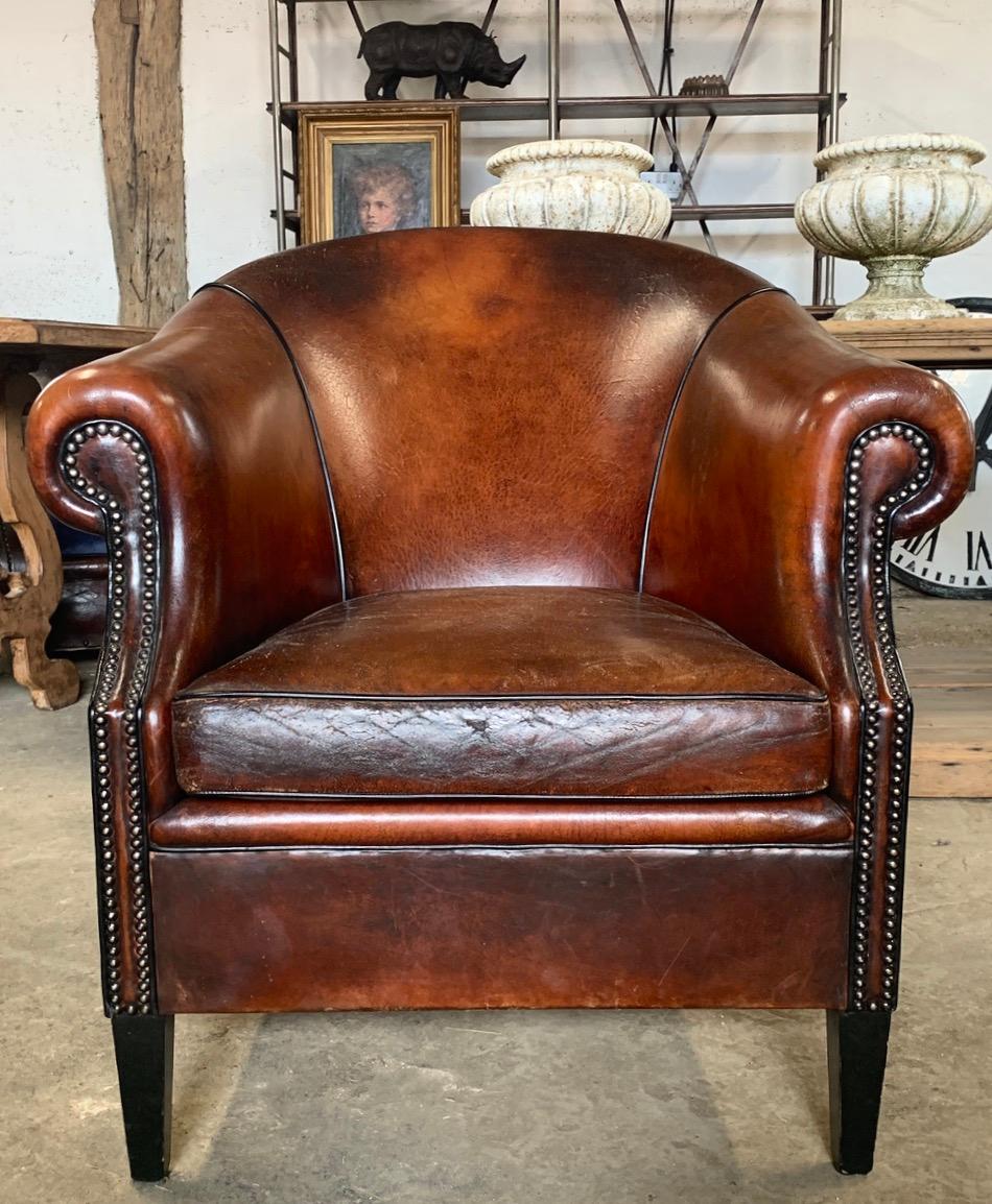 A beautiful and stylish Dutch sheep leather armchair with brass studding. The leather has a great color and wear from age and use which adds to the look. Removable cushion for easy cleaning. Circa 1980.