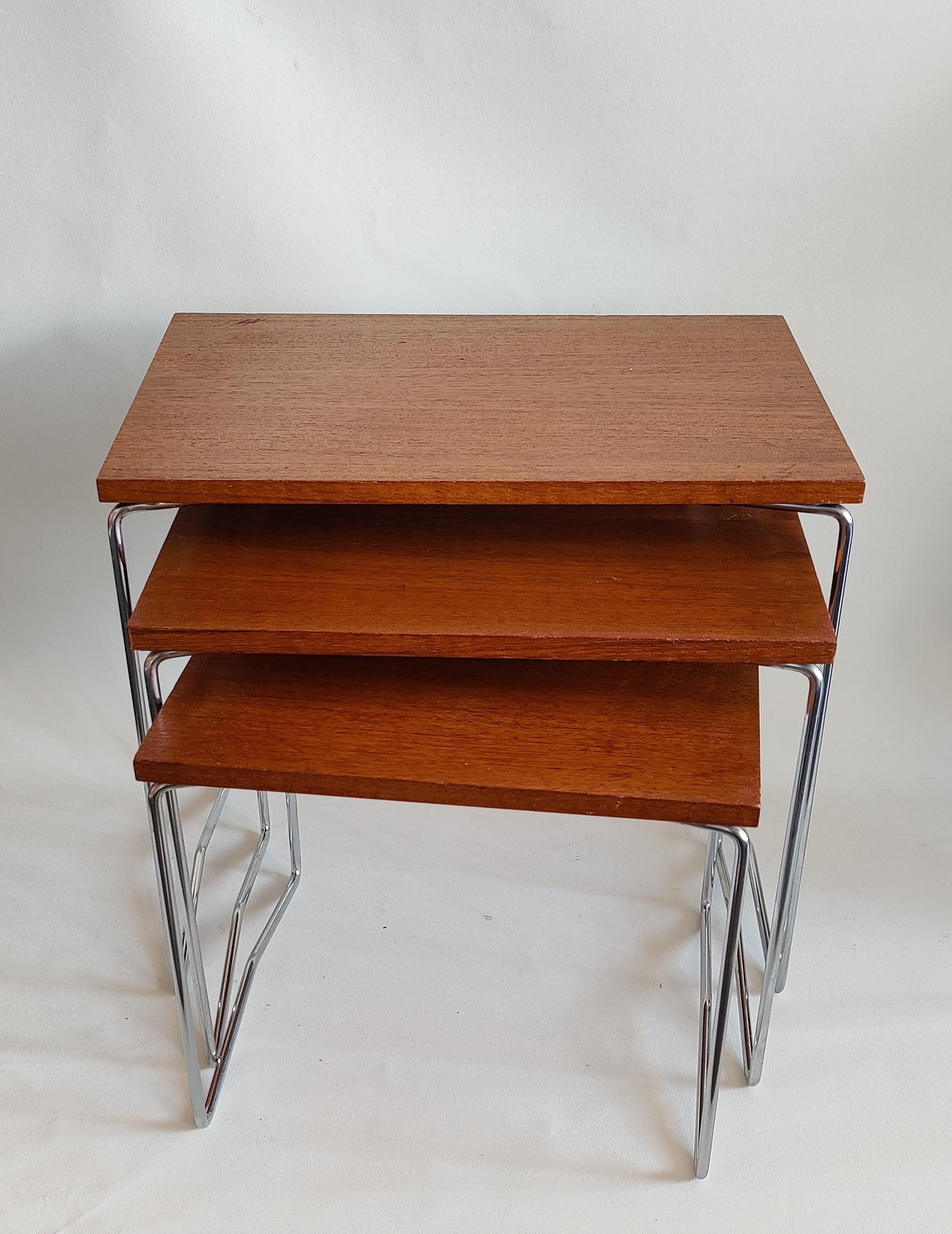Set of three mid-century Brabantia nesting tables from the 1960’s. Top is made of teak veneer on a steel frame. 
These three nesting tables are in good sturdy condition. There are some signs of use on top of the tables, like some scratches (biggest