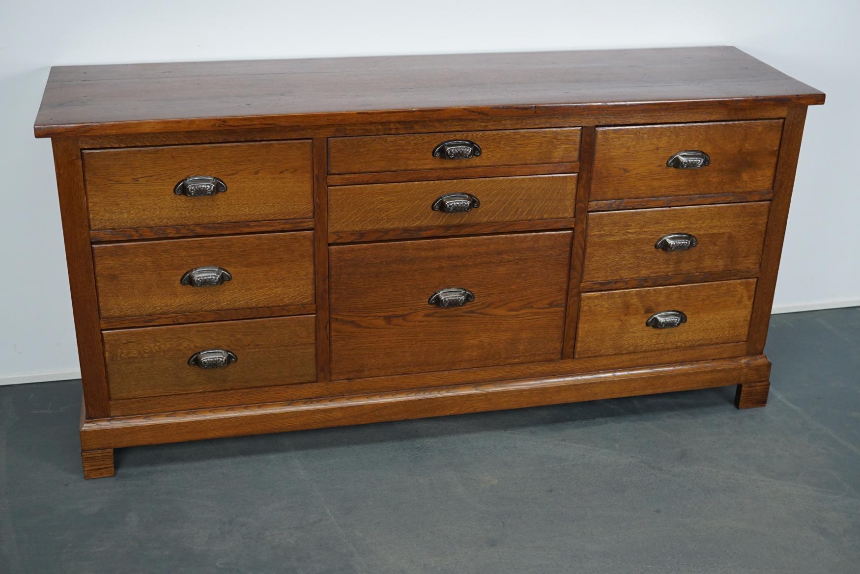 This apothecary / filing cabinet was produced during the 1930s in the Netherlands. This piece features 9 large drawers. The interior dimensions of the drawers are: D, W, H 32 x 39.5 x 14 cm, 32 x 48.5 x 5.7 cm and 32 x 48.5 x 29.5.