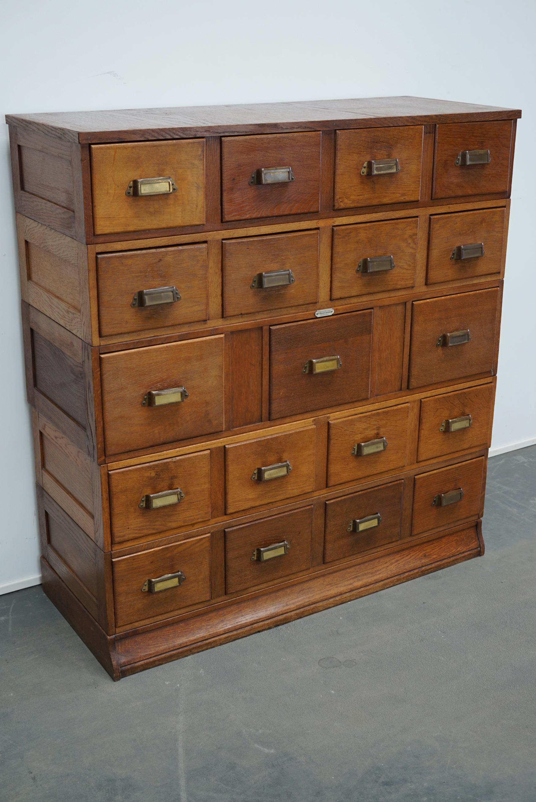 This apothecary cabinet was produced during the 1930s in the Netherlands. This stackable piece features 19 drawers with nice brass cup handles. The interior dimensions of the drawers are: D x W x H 35 x 20 x 10 / 14 cm and 35 x 23 x 14 / 18 cm for