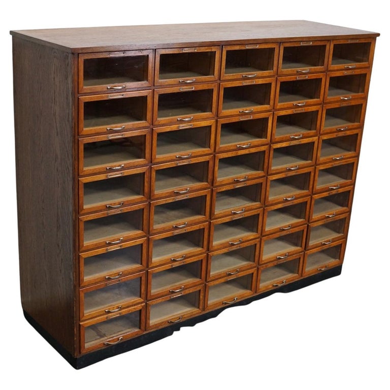 This haberdashery cabinet was produced during the 1930s in the Netherlands. It features 40 drawers in oak with glass fronts and metal handles. It was originally used in the department store Maussen in the city of Maastricht which was closed in 1981.