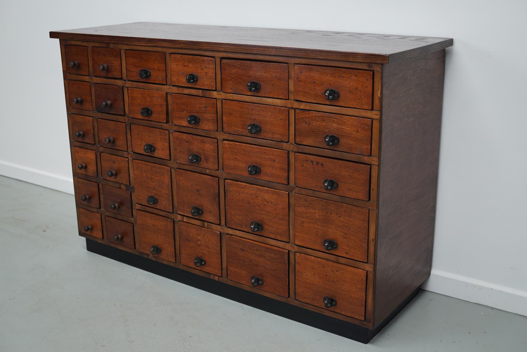This jewelers / watchmaker cabinet was designed and made circa 1930/1940 in the Netherlands. It features 32 oak fronted drawers in many different sizes.