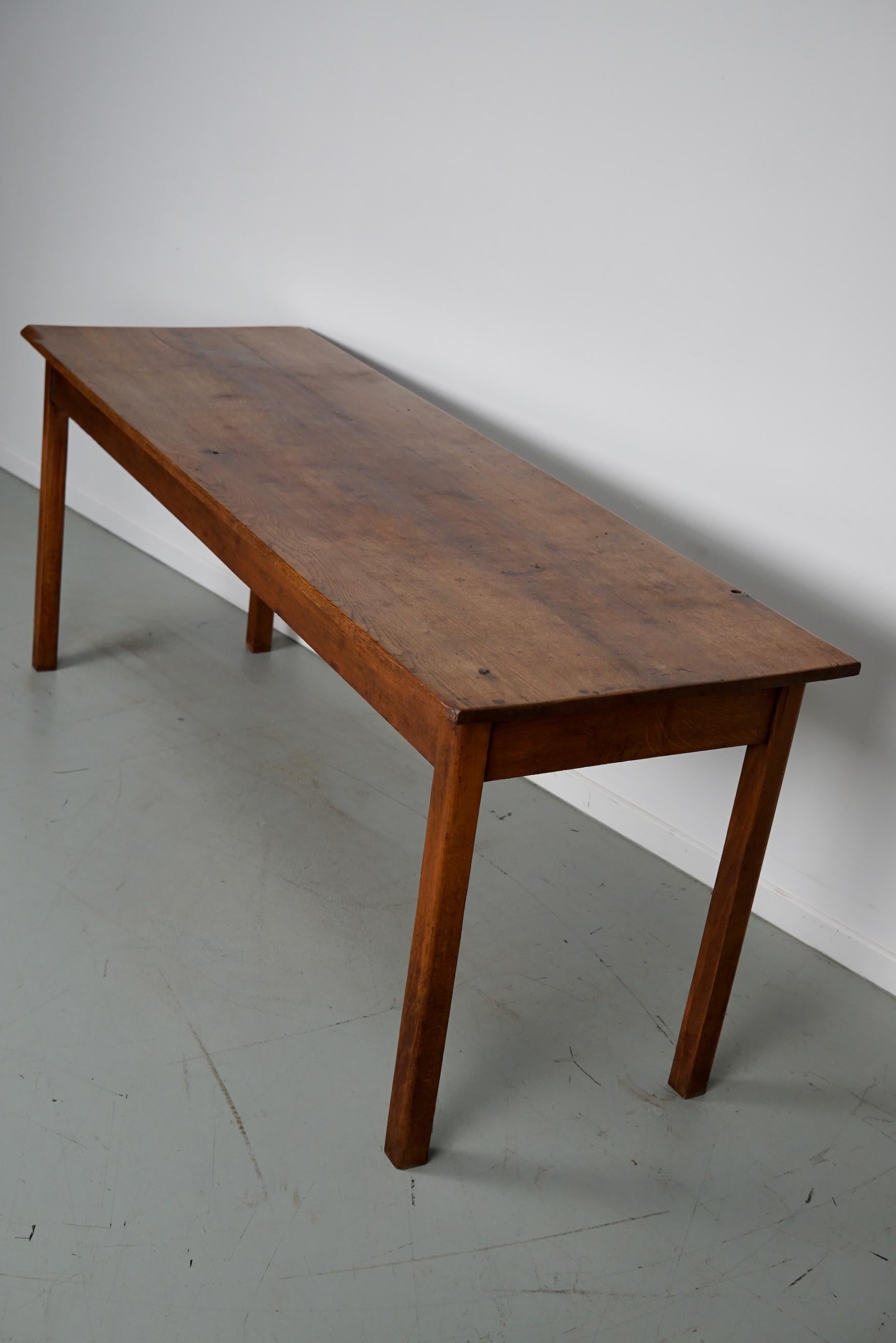 This table was made circa 1930s in the Netherlands and was used in a church until recently. It was made from solid oak and it retained a nice and warm patina and color over the years. The knee height is 63.5 cm.