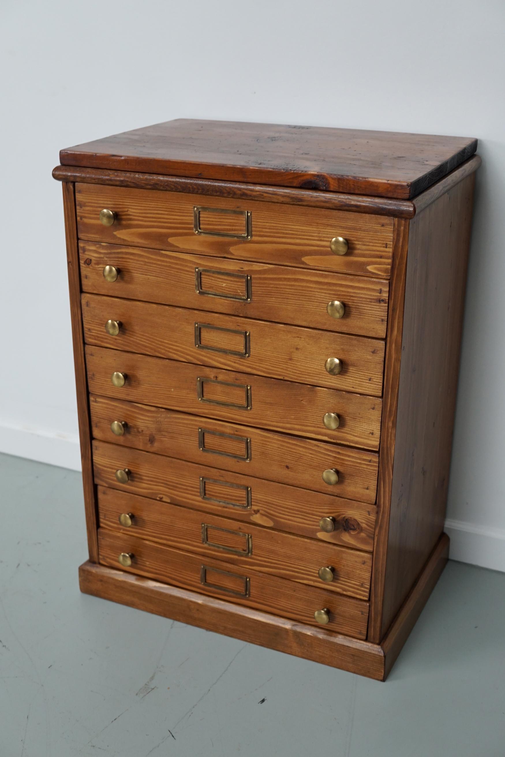 This jewelers / watchmaker cabinet was designed and made circa 1930 in the Netherlands. It features 8 pine fronted drawers with brass hardware.