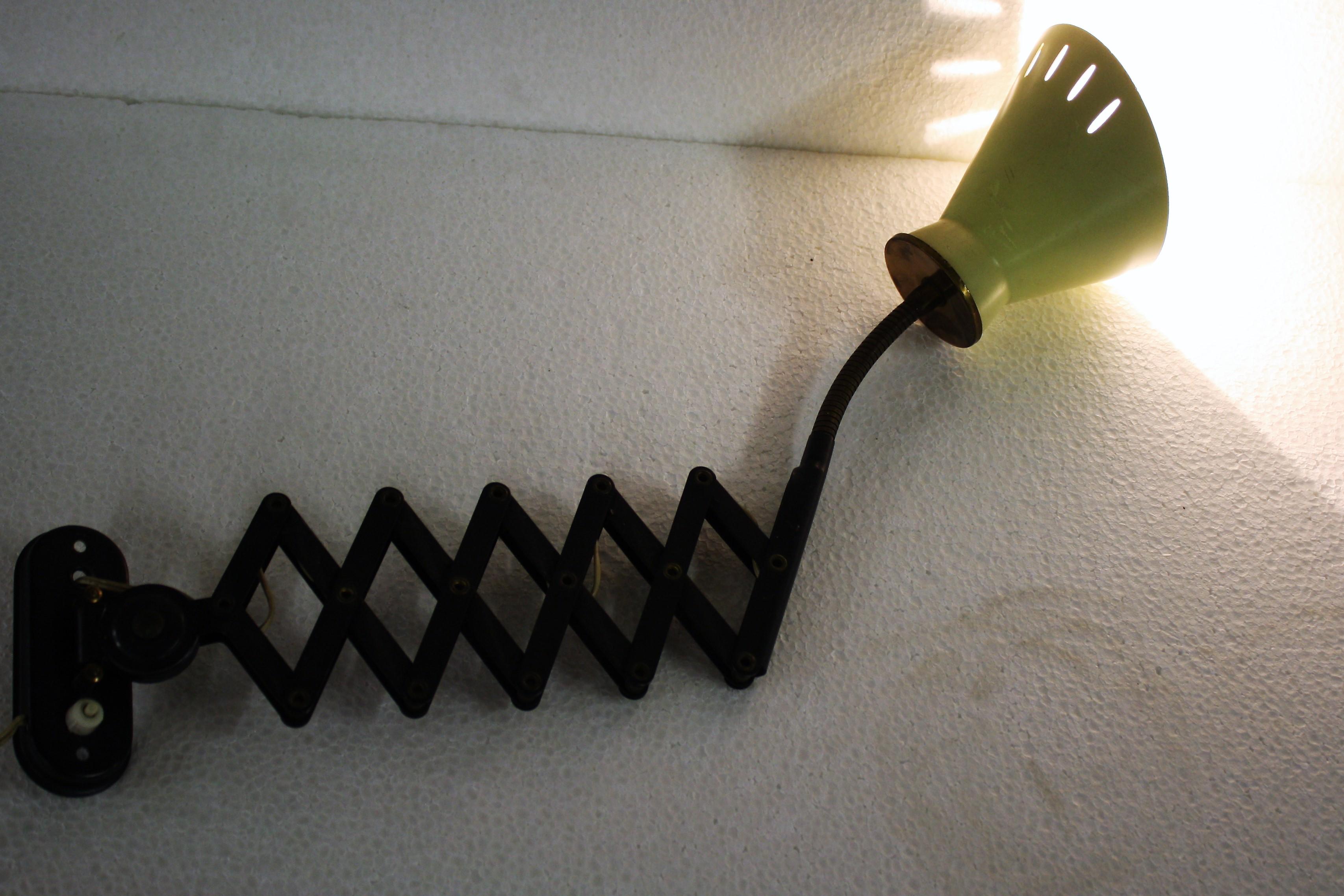 Lampada a forbice estraibile originale degli anni '50.

Questo tipo di applique era molto popolare grazie alla sua versatilità.

Questo particolare esemplare è dotato di un braccio flessibile in ottone che rende la lampada ancora più