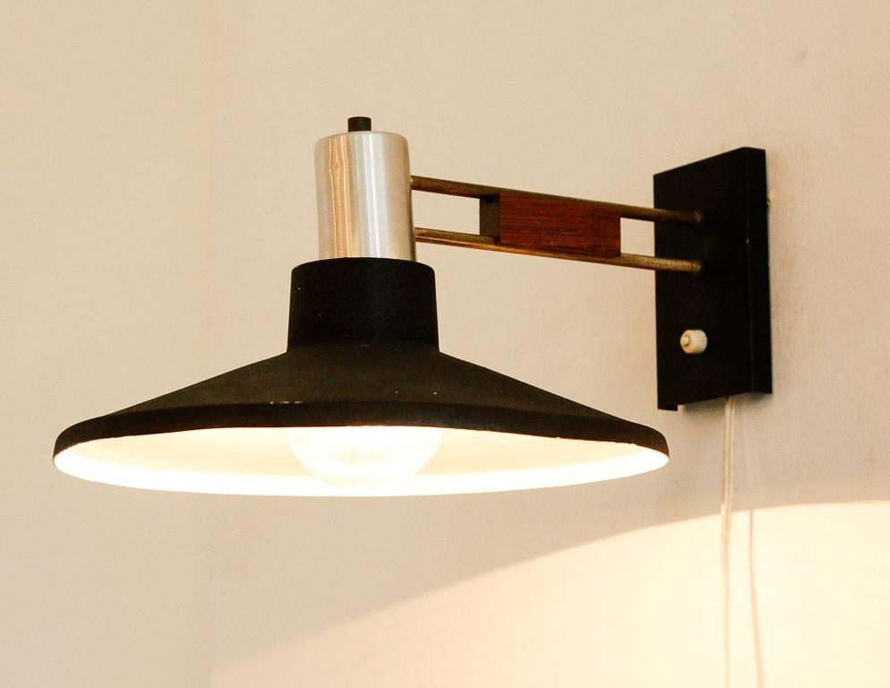 Vintage wall sconce from Holland, 1960s. Black textured dish-shaped shade, silver hardware and teak detail.