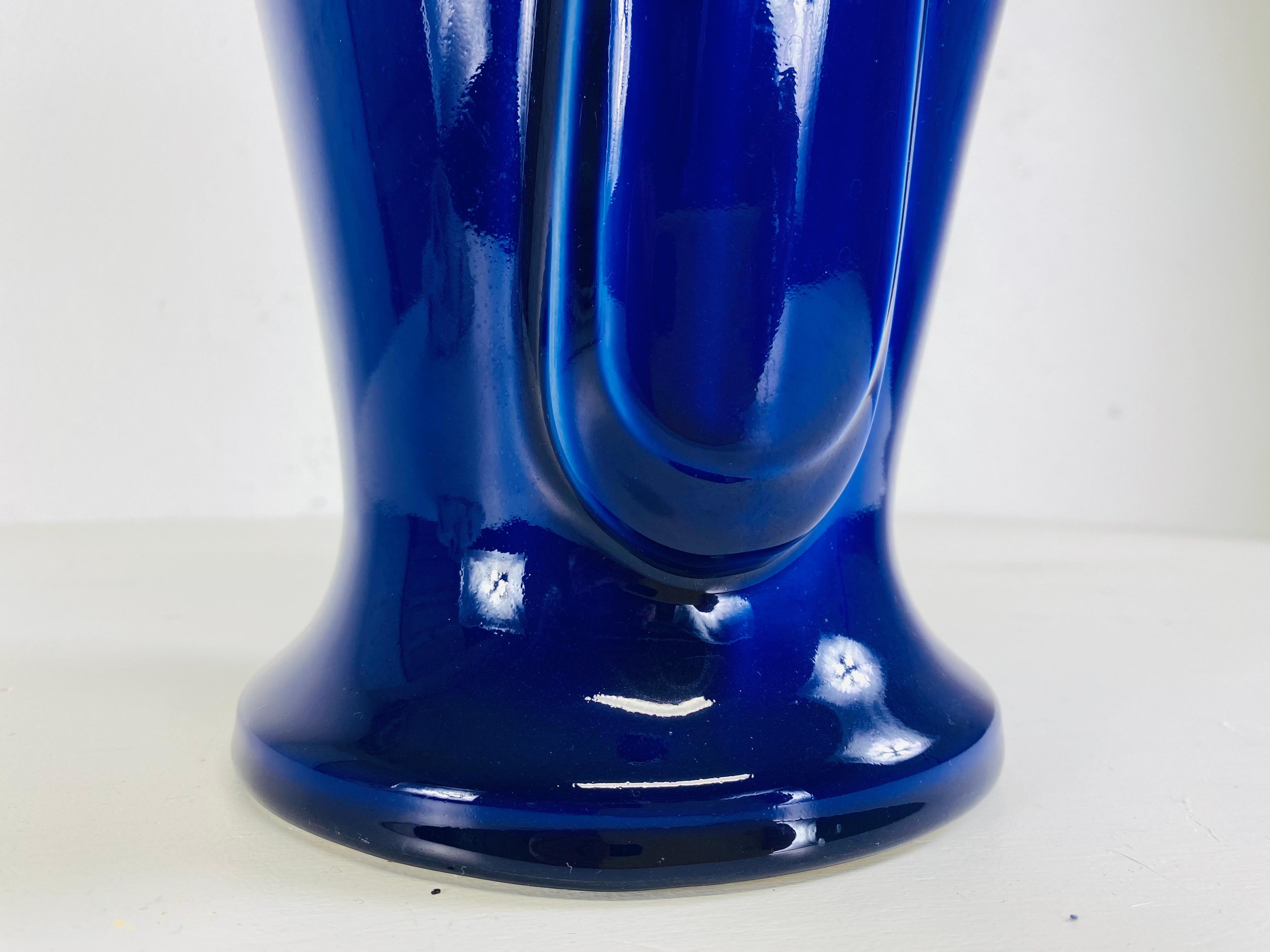 This is a 20th century vintage dynamic cobalt blue art deco style vase. This intense cobalt blue vase has two beautiful scrolls handles on either side of the vase. This Cobalt blue vase was made in America circa 1980.