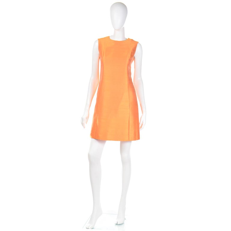 This is a vintage 1960's vibrant tangerine orange 2 piece outfit that includes a pretty sleeveless sheath dress and a nice matching coat! This bright minimalist mod ensemble is perfect to mix and match with other pieces or to wear together as a