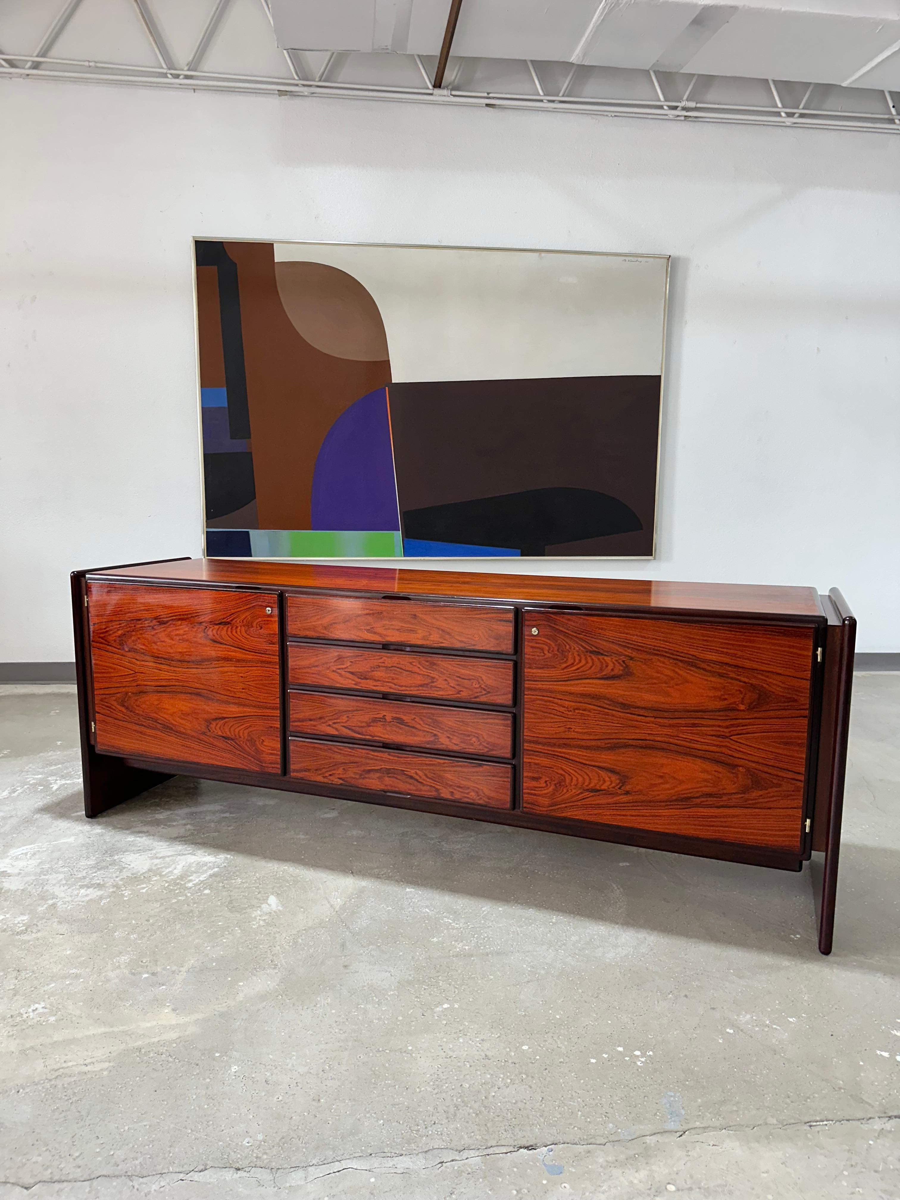 Vintage Sideboard aus dänischem Palisanderholz um 1970 im Stil von Dyrlund, Hersteller unbekannt. Offener Stauraum verbirgt sich hinter Türen an beiden Enden und vier Schubladen in der Mitte. Die Rückseite ist vollständig fertiggestellt, so dass sie