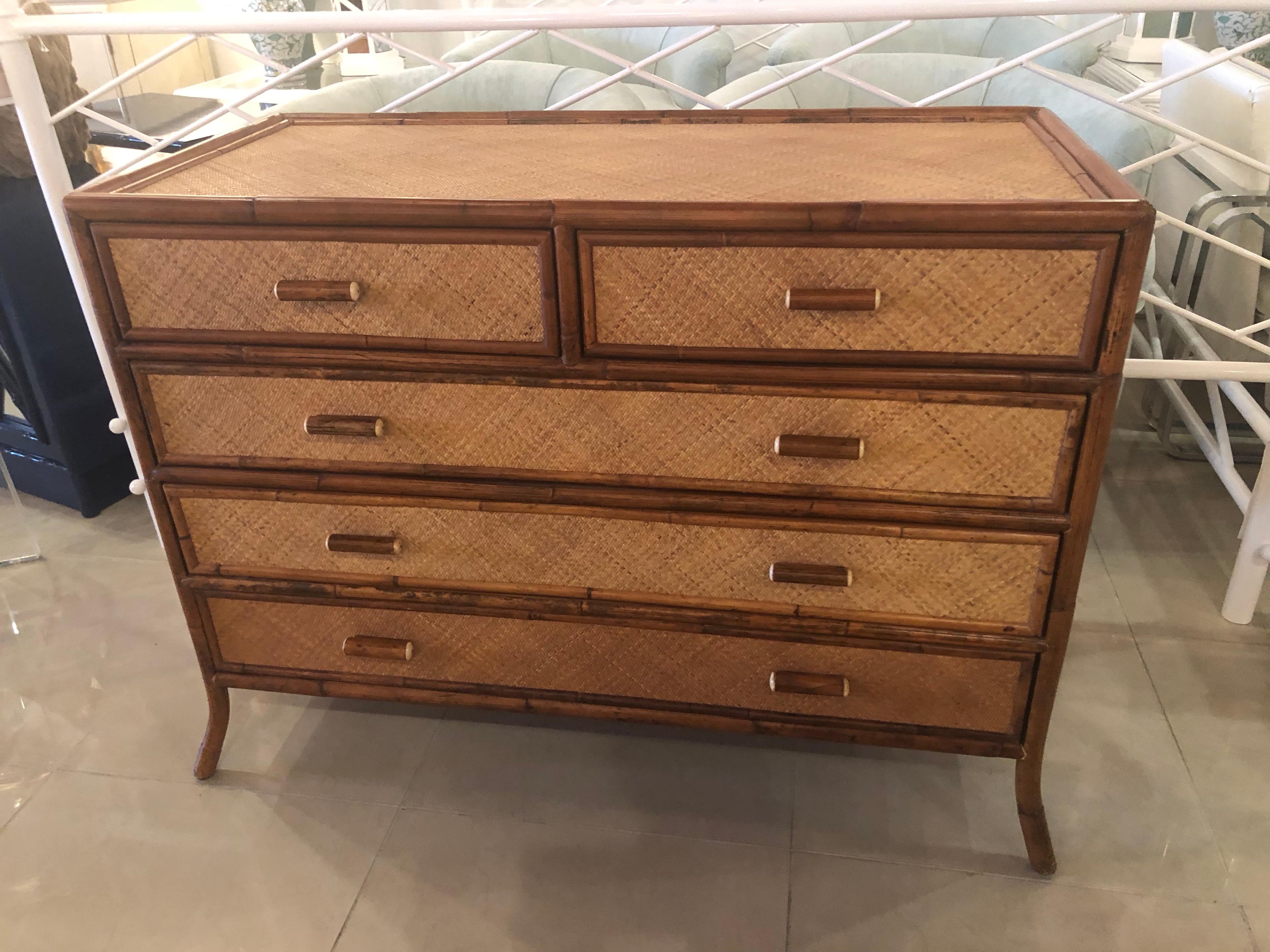 Lovely vintage grasscloth weaved cane, burnt bamboo and rattan details on this chest of drawers, credenza, dresser. There are 5 drawers, slant legs, original finish may have color variation due to natural materials.
